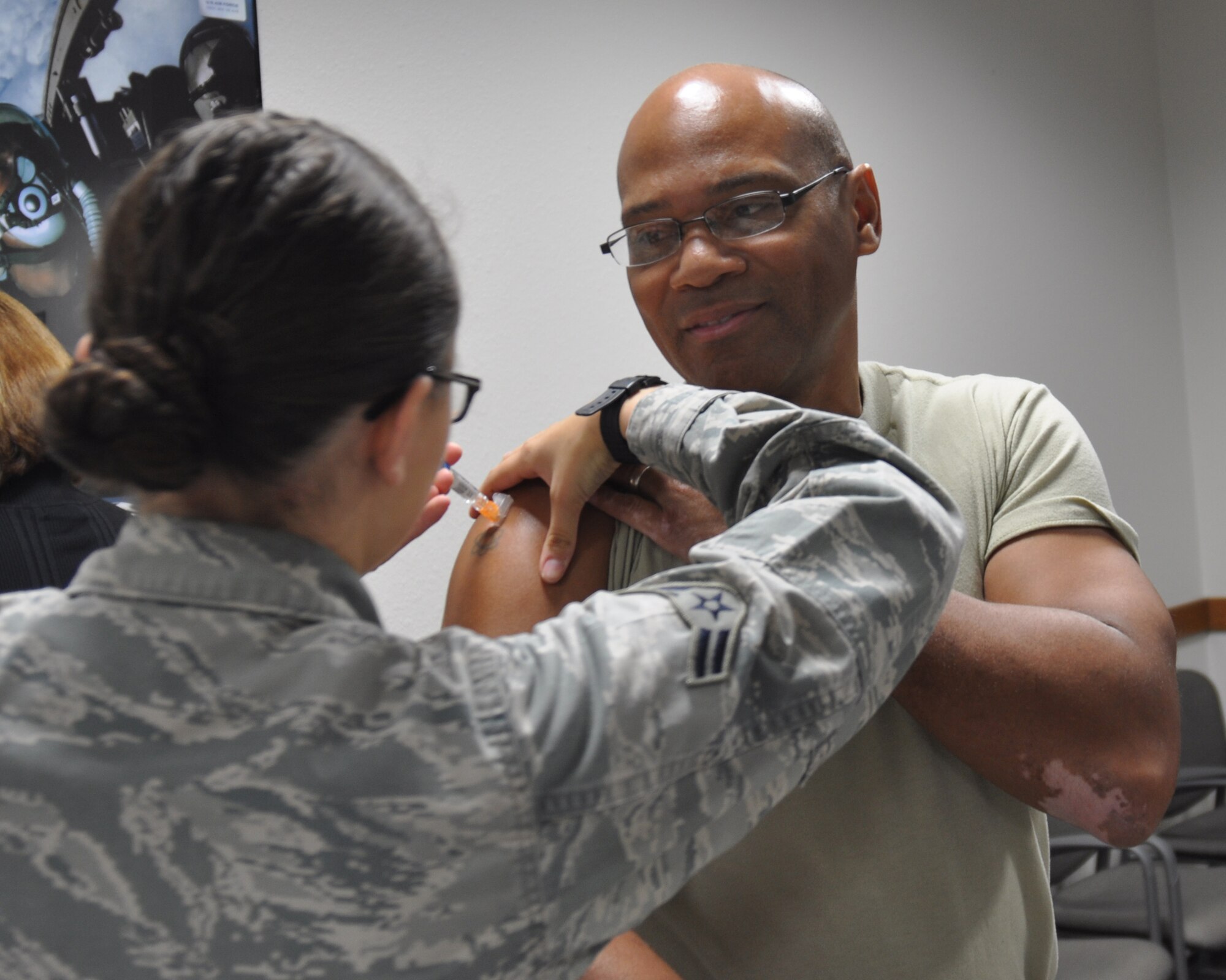Col. Marcus Johnson, Air Force Recruiting Service vice commander, receives his annual flu shot at Headquarters AFRS, Joint Base San Antonio-Randolph, Texas, Oct. 20. Airman 1st Class Abby Roetzel, 359th Medical Operations Squadron medical technician, administers the vaccine. Vaccinating is one of the most important ways to prevent the spread of the highly contagious influenza virus. (U.S. Air Force photo/Master Sgt. Andrew Stephens)