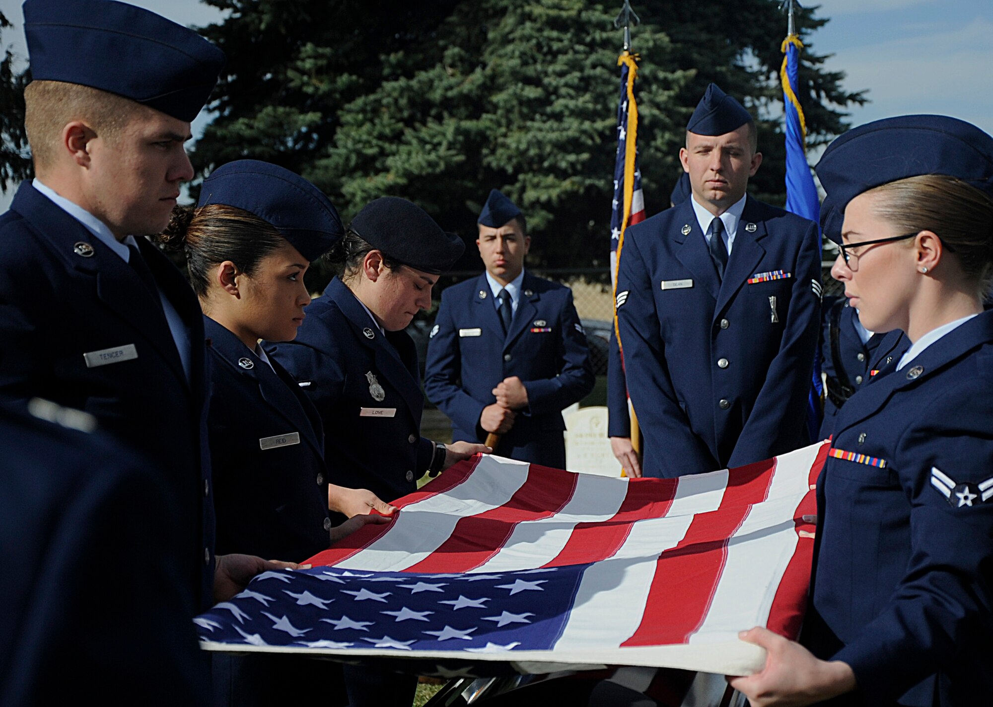 Six new graduates perform a flag-folding ceremony Oct. 31 during a mock funeral at the F.E. Warren Air Force Base, Wyo., cemetery. The ceremonial folding of a flag is performed over the casket to honor those who have passed away.   (U.S. Air Force photo by Airman 1st Class Brandon Valle)