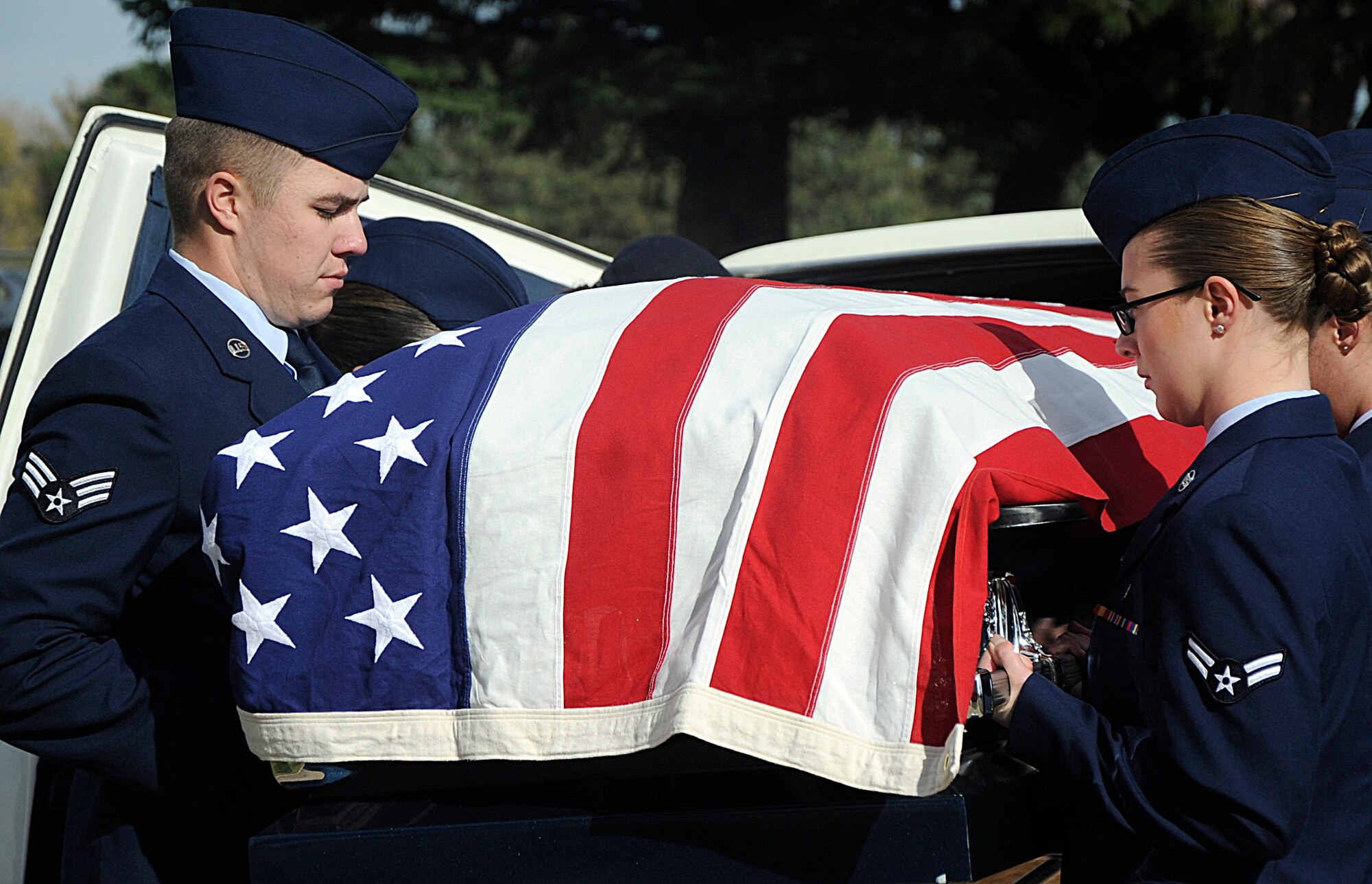New honor guard graduates lift an empty casket out of a hearse Oct 31 as part of their graduation ceremony at the F.E. Warren Air Force Base, Wyo., cemetery. The new graduates performed a mock funeral during the graduation to showcase the skills they learned during a two-week training. (U.S. Air Force photo by Airman 1st Class Brandon Valle)