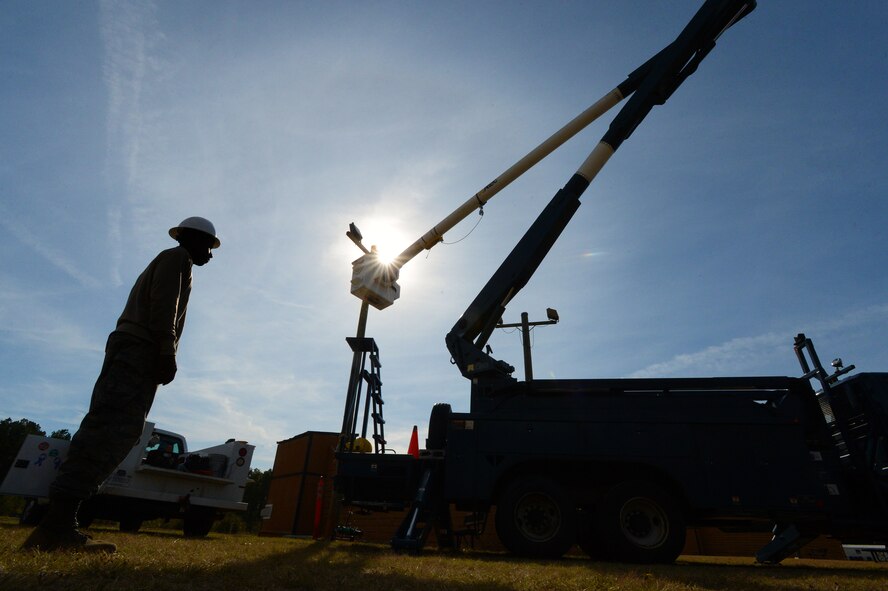 U.S. Air Force Airmen assigned to the 20th Civil Engineer Squadron electrical systems shop, replace the lights on a light pole at the 20th Force Support Squadron skeet and trap range at Shaw Air Force Base, S.C., Nov. 4, 2014. During the two-day project, 20th CES Airmen replaced one of six light poles and installed two new 400-watt bulbs. (U.S. Air Force photo by Airman 1st Class Jensen Stidham/Released) 