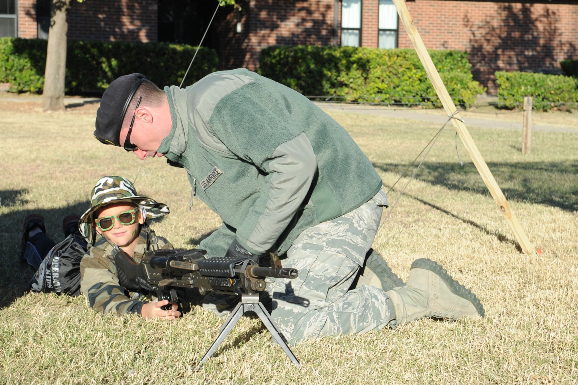 GOODFELLOW AIR FORCE BASE, Texas -- Staff Sgt. Jeremy A. Davis, 17th Security Forces Squadron unit programs coordinator, shows a youth how to position himself behind an M240B, crew served mounted weapon, during Operation KIDS Nov. 1. Operation KIDS is designed to give military children insight into what their parents go through when they deploy. (U.S. Air Force photo/ Staff Sgt. Laura R. McFarlane)