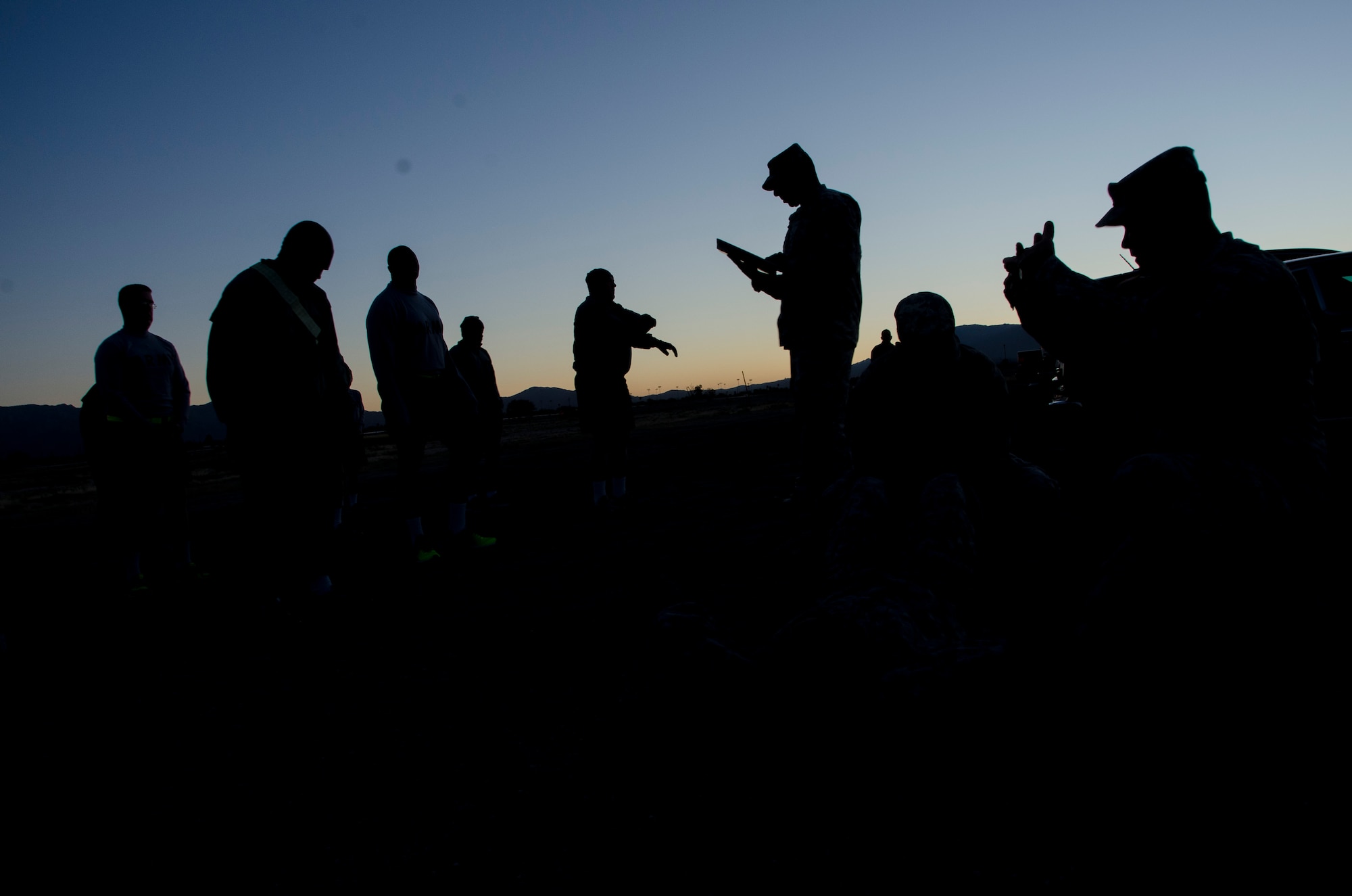 Members from the 1st Battlefield Coordination Detachment gather around and observe demonstrations on correct form before taking the Army physical fitness test at Davis-Monthan AFB, Ariz., Nov. 4, 2014. All soldiers in the Active Army, Army National Guard and Army Reserve are required to take the Army Physical Fitness Test. (U.S. Air Force photo by Staff Sgt. Adam Grant/Released)