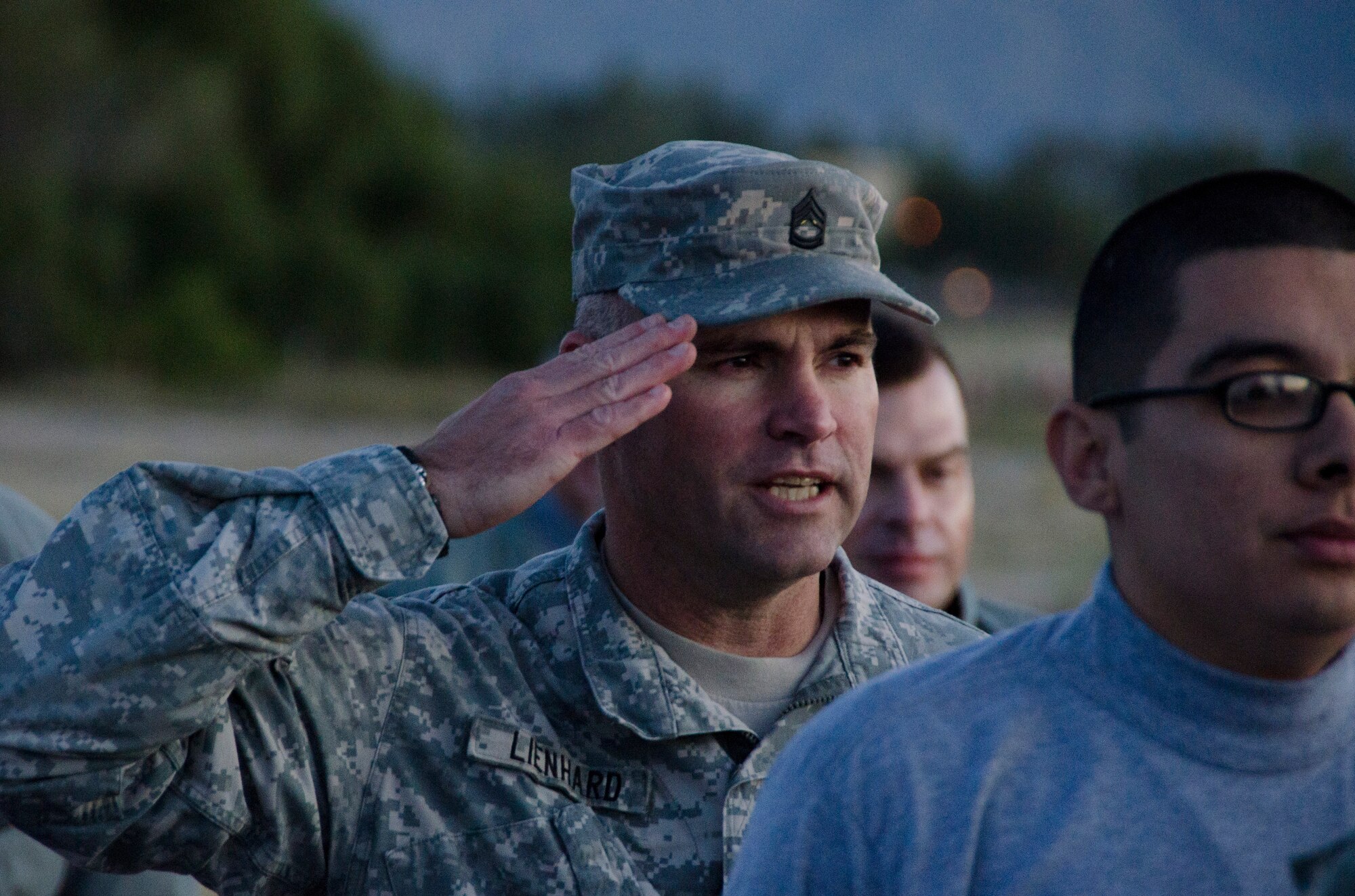 Sgt. 1st Class Andre Lienhard, 1st Battlefield Coordination Detachment Plans NCOIC, salutes and gives accountability of all of his troops not present during a formation before administering the Army physical fitness test at Davis-Monthan AFB, Ariz., Nov. 4, 2014. During the test Lienhard ensured those taking the test adhered to standards. (U.S. Air Force photo by Staff Sgt. Adam Grant/Released)