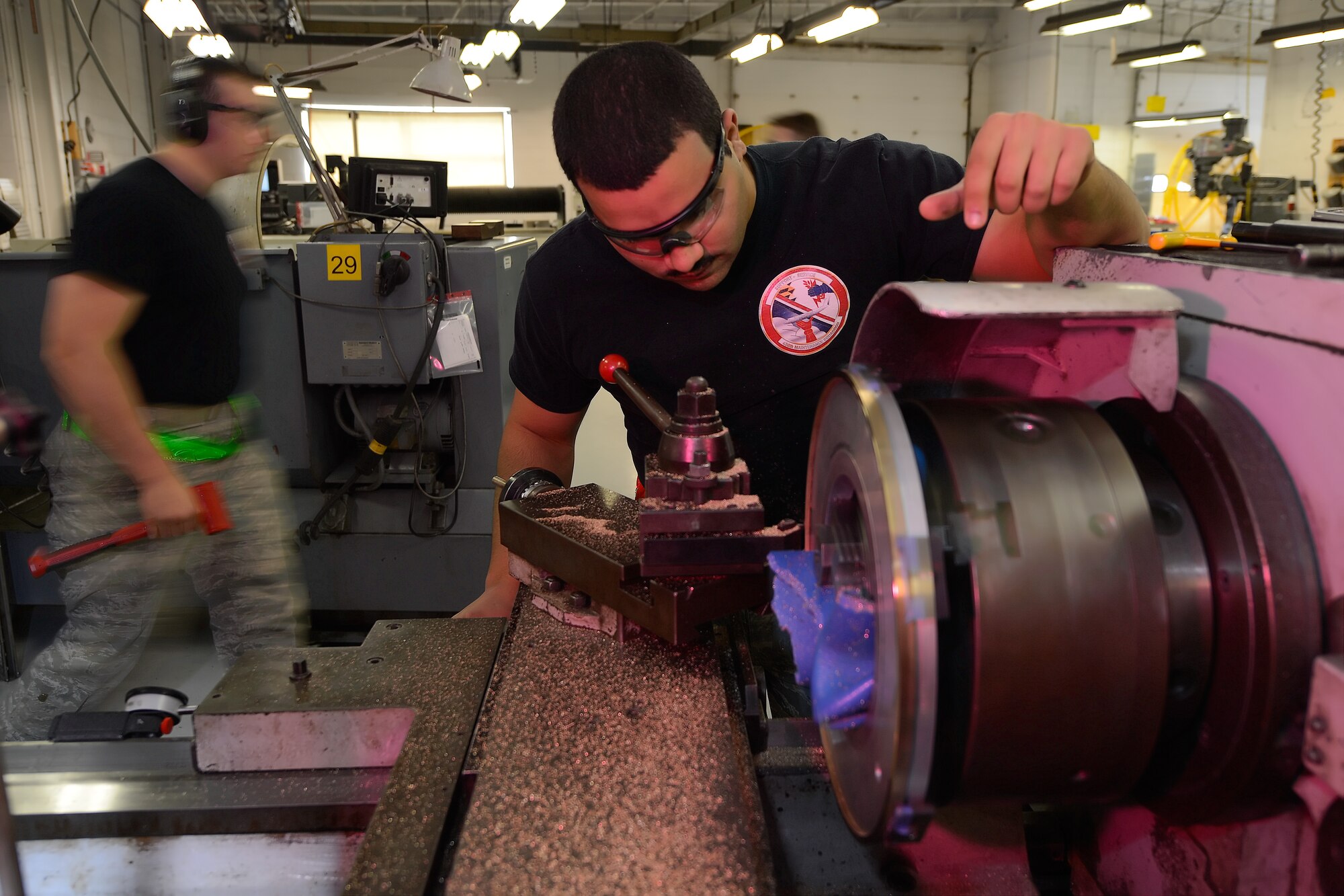 Senior Airman Alexander Wilke, 436th Maintenance Squadron aircraft metals technician journeyman, leans over to visually inspect a part being turned on a lathe on Oct. 31, 2014, at Dover Air Force Base, Del. The part being made is for the main landing gear strut of a C-5 Galaxy currently undergoing heavy maintenance at the base. (U.S. Air Force photo/Greg L. Davis)