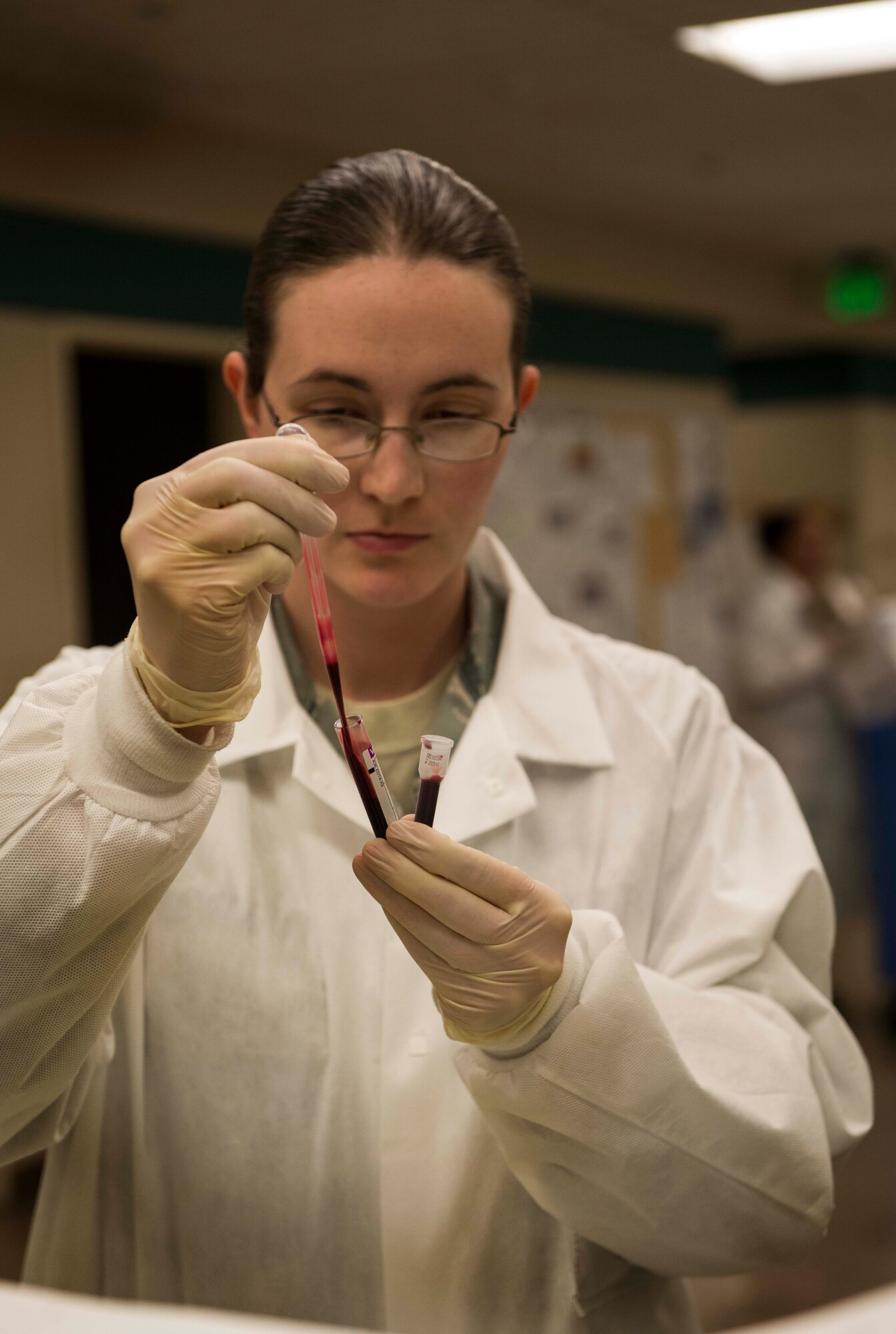 SSgt. Hollie Crawford, NCO in charge of the 5 MDG medical lab, examines a blood sample under a microscope on Minot Air Force Base, N.D., Oct. 29, 2014. By closely reviewing the sample, Crawford will be better able to detect any infection or bacteria found in the sample. (U.S. Air Force photo/Airman 1st Class Lauren Pitts)
