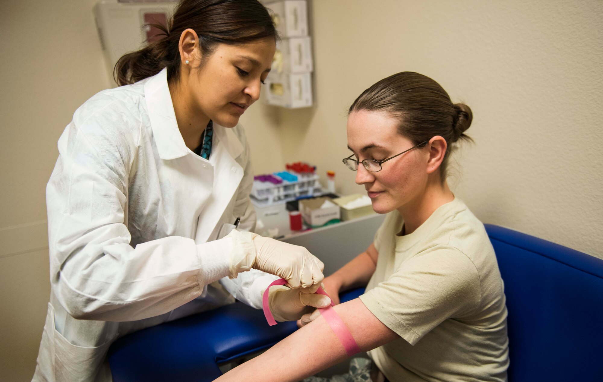 Charmayne Benally, 5th Medical Group phlebotomist, prepares to draw a blood sample from SSgt. Hollie Crawford, NCO in charge of the 5 MDG medical lab on Minot Air Force Base, N.D., Oct. 29, 2014. The Airmen and nurses in the medical lab are responsible for testing blood and urine samples to ensure base-wide health and mission sustainment. (U.S. Air Force photo/Airman 1st Class Lauren Pitts) 