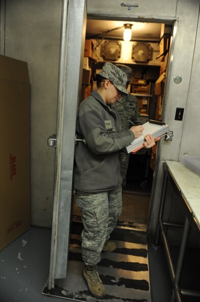 Senior Airman Jessica Gilmore, 5th Medical Operations Squadron public health technician, records the temperature of a freezer where food is stored during an inspection at the dining facility on Minot Air Force Base, N.D., Oct. 28, 2014. During inspections temperature readings are taken anywhere food is heated or chilled at a consistent temperature, including refrigerators and the serving line. (U.S. Air Force photo/Senior Airman Stephanie Morris)