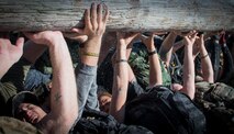 Participants pass a log during the GORUCK Cohesion Challenge Sept. 11, at Eglin Air Force Base, Fla. This elite team-building event, led by a Special Forces veteran, featured military inspired challenges and missions. Only 24 out of the original 27 completed all obstacles. Eglin is the fifth base to complete the Team Cohesion Challenge, which is modeled after special operations training. (U.S. Air Force photo/Tech. Sgt. Jasmin Taylor)