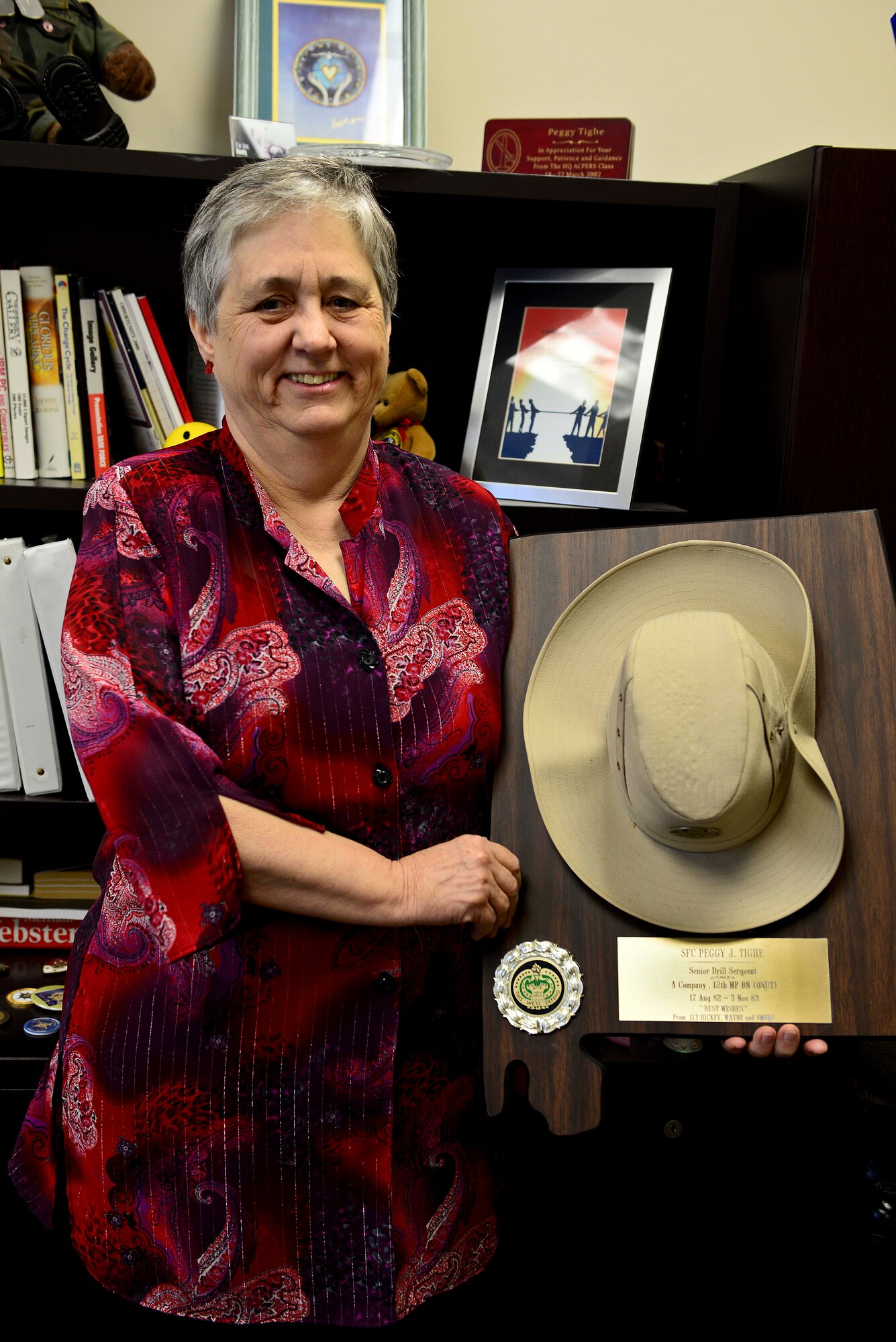 Peggy Tighe, U.S. Army Training and Doctrine Command diversity office director, shows off the drill sergeant’s cover she wore when she served in the U.S. Army Oct. 21, 2014, at Fort Eustis, Va. Tighe will retire this year after more than 20 years of Army civil service. (U.S. Air Force photo by Airman 1st Class Kimberly Nagle/Released) 