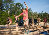 1st Lt. John Vidoni, of the 40th Flight Test Squadron, balances on a beam across a mud pit at the Emerald Coast MudRun for Orphans in Niceville Fla., May 17. Active duty and reserve service members came out to get dirty in either the morning or afternoon 5K challenges. The participants could run, crawl, climb, slide, and scale their way through this adventure race.  (U.S. Air Force photo/Tech. Sgt. Jasmin Taylor)