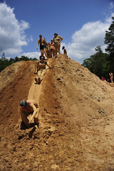 A group slides down the last obstacle before running to the finish of the Emerald Coast MudRun for Orphans in Niceville Fla., May 17. Active duty and reserve service members came out to get dirty in either the morning or afternoon 5K challenges. The participants could run, crawl, climb, slide, and scale their way through this adventure race.  (U.S. Air Force photo/Tech. Sgt. Jasmin Taylor)