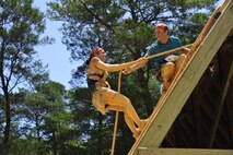 A competitor reaches to help his teammate up the rope at the Emerald Coast MudRun for Orphans in Niceville Fla., May 17. Active duty and reserve service members came out to get dirty in either the morning or afternoon 5K challenges. The participants could run, crawl, climb, slide, and scale their way through this adventure race.  (U.S. Air Force photo/Tech. Sgt. Jasmin Taylor)