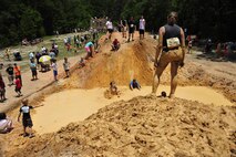 A member waits at the top of the mound for the rest of her team to catch up at the Emerald Coast MudRun for Orphans in Niceville Fla., May 17. Active duty and reserve service members came out to get dirty in either the morning or afternoon 5K challenges. The participants could run, crawl, climb, slide, and scale their way through this adventure race.  (U.S. Air Force photo/Tech. Sgt. Jasmin Taylor)