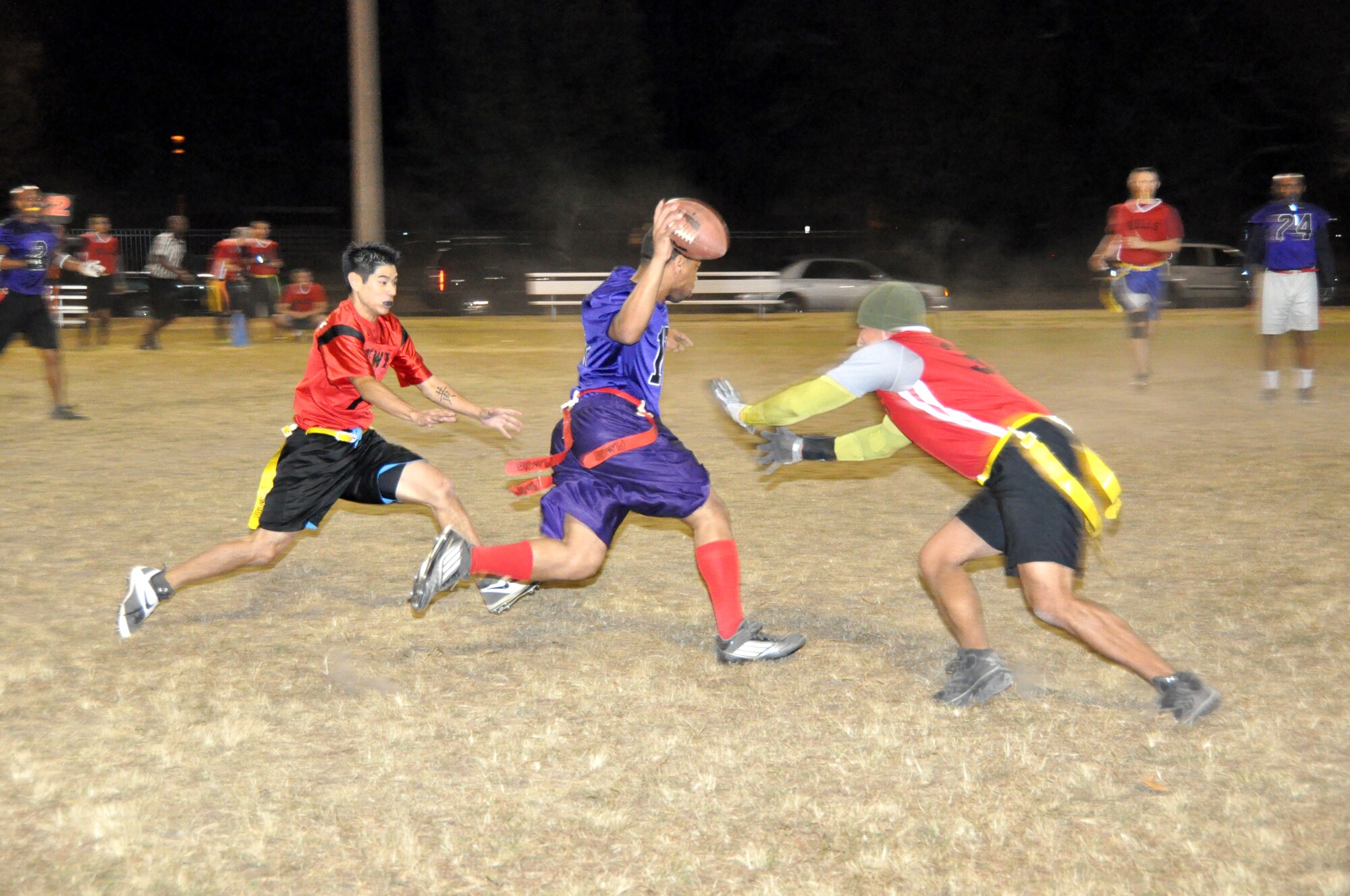 403rd Wing Quarterback Patrick Green dodges two 335th defenders during the third round of the Keesler Air Force Base flag football playoffs Nov 3. (U.S. Air Force photo/Master Sgt. Brian Lamar)