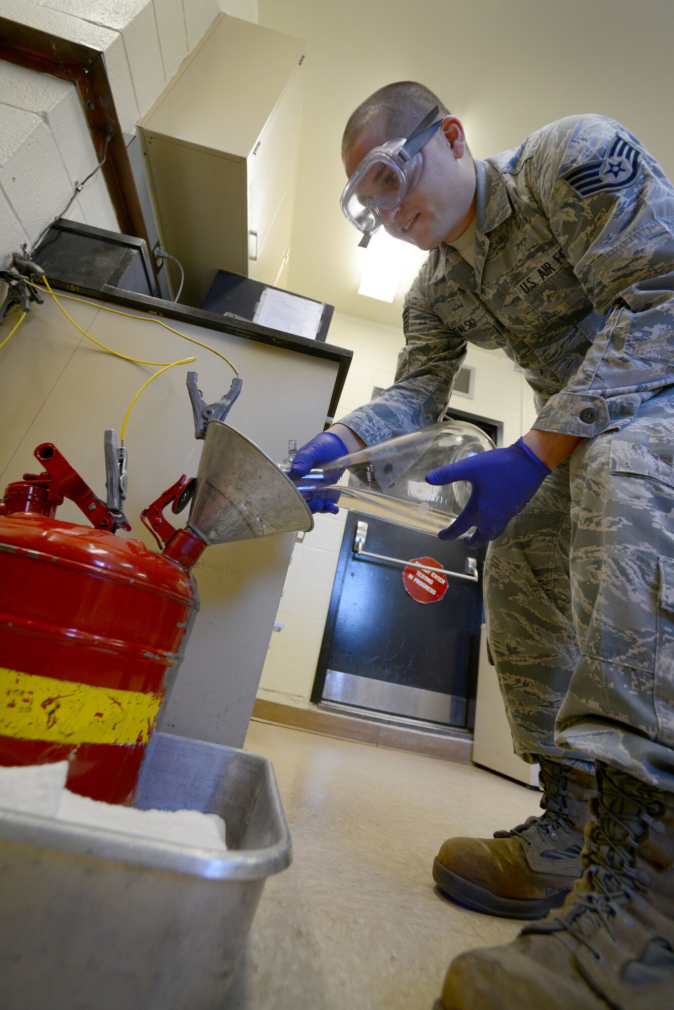 U.S. Air Force Staff Sgt. Andrew Mitalski, 20th Logistics Readiness Squadron fuels laboratory specialist, drains leftover fuel after quality testing, Shaw Air Force Base, S.C., Oct. 30, 2014. Airmen test each fueling station to ensure the fuel on base is held to the highest standards. (U.S. Air Force photo by Senior Airman Ashley L. Gardner/Released)