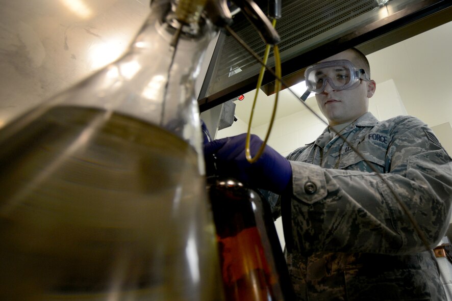 U.S. Air Force Staff Sgt. Andrew Mitalski, 20th Logistics Readiness Squadron fuels laboratory specialist, checks fuel for purity at Shaw Air Force Base, S.C., Oct. 30, 2014. The fuels laboratory personnel monitor and maintain the quality of all aviation fuel, ground fuel, and cryogenic products by taking and analyzing samples. (U.S. Air Force photo by Senior Airman Ashley L. Gardner/Released)