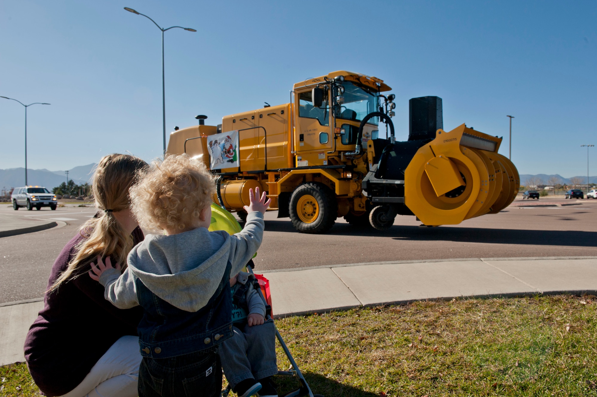 PETERSON AIR FORCE BASE, Colo. – Eli Wood, 2, waves to a snow truck driver as he drives to the next stop of the Snow Parade Oct. 28. The Snow Parade was put on by the 21st Civil Engineer Squadron to familiarize and show off the snow plows, dump trucks, fire trucks and other equipment to base personnel and their families. The children also were able to hang out with Santa who rode in on a fire truck to greet them. (U.S. Air Force photo/Airman 1st Class Rose Gudex)