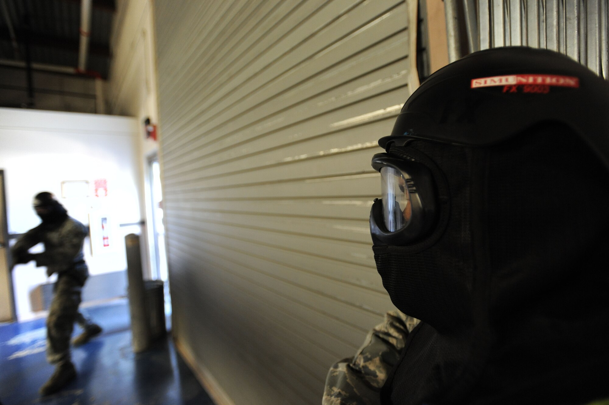 U.S. Air Force Staff Sgt. Edward Leslie, 20th Security Forces Squadron standards and evaluation technician, observes a group of Airmen entering a building in search of a simulated active shooter during a training session at Shaw Air Force Base, S.C., Oct. 29, 2014. During the training, Leslie observes the Airmen closely so that they meet the criteria of the training. (U.S. Air Force photo by Airman 1st Class Michael Cossaboom/Released)