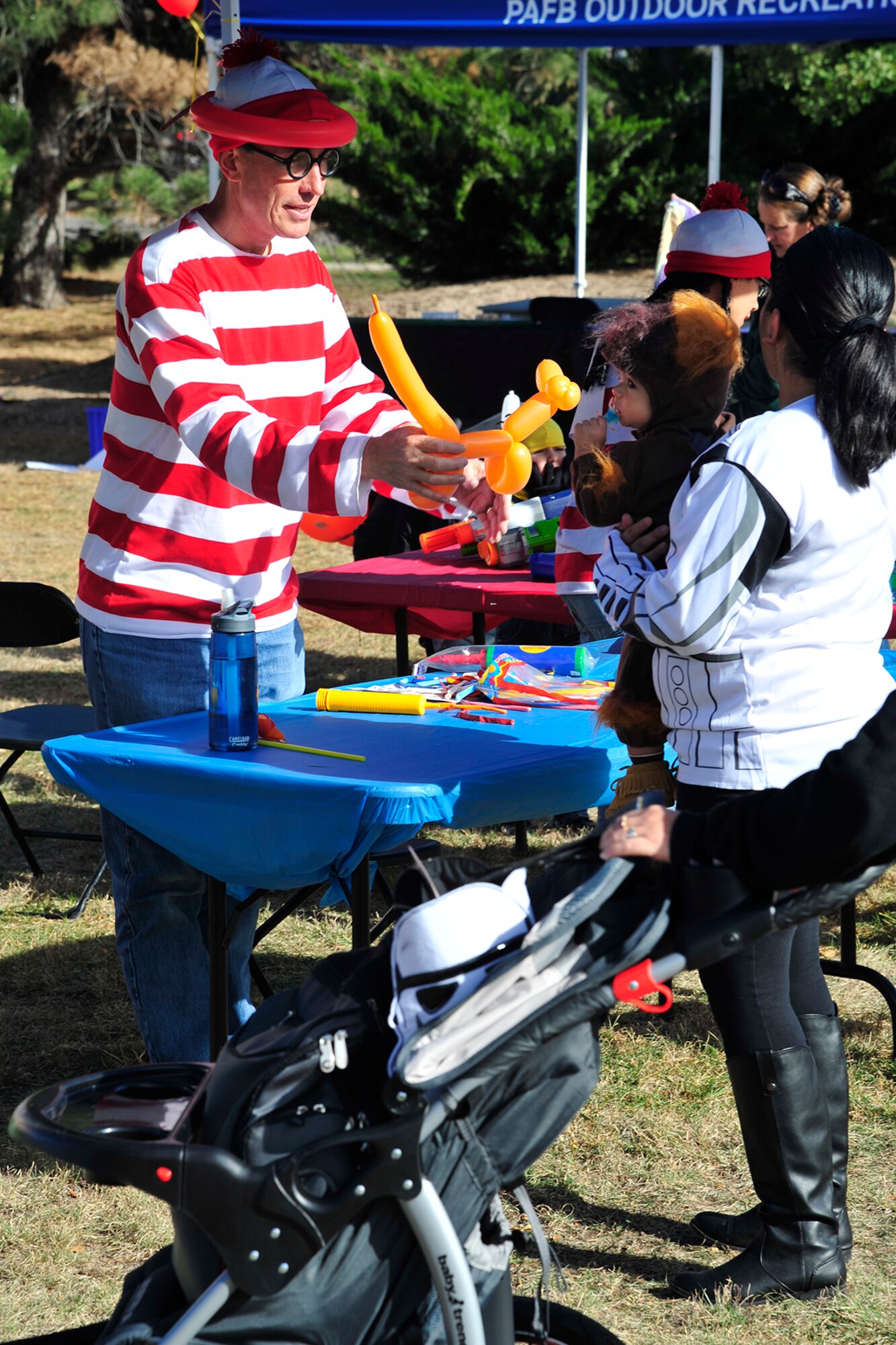 PETERSON AIR FORCE BASE, Colo. — Maj. Mark Olsen, 21st Mission Support Group Public Health Flight commander, creates a balloon animal for one of the children at the 21st Medical Group 2014 Fall Festival Oct. 31. Members from the 21st MDG, chapel, the fire department, American Red Cross, Airman and Family Readiness Center, 21st Security Forces Squadron and more provided preventative health information, health and fitness-related games, music and healthy snacks. The health fair and festival was open to all ages. (U.S. Air Force photo/Robb Lingley)