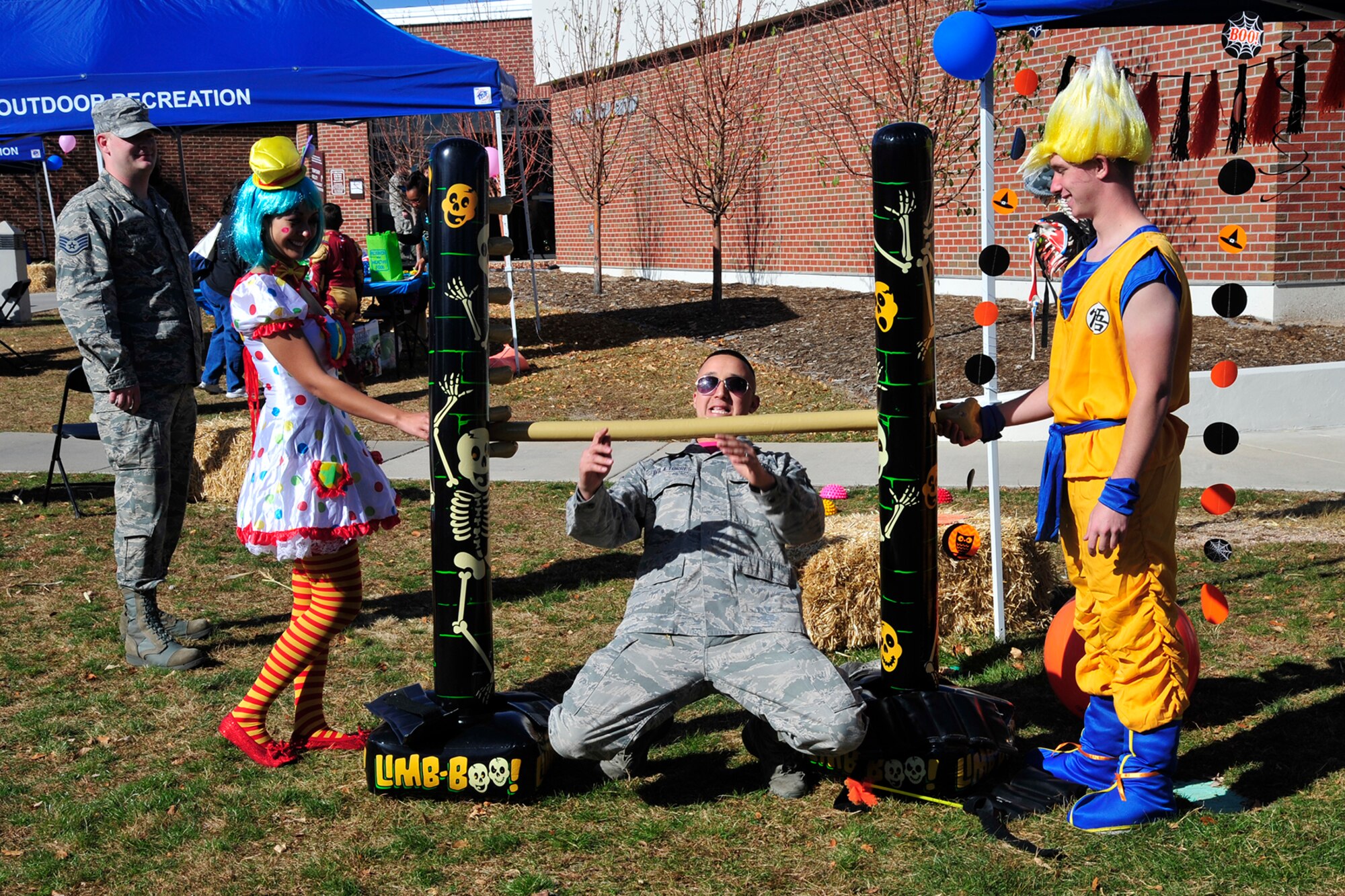 PETERSON AIR FORCE BASE, Colo. — Senior Airman Fabian Avila Torres, 21st Dental Squadron, does the limbo at the 21st Medical Group 2014 Fall Festival Oct. 31. Members from the 21st MDG, chapel, the fire department, American Red Cross, Airman and Family Readiness Center, 21st Security Forces Squadron and more provided preventative health information, health and fitness-related games, music and healthy snacks. The health fair and festival was open to all ages. (U.S. Air Force photo/Robb Lingley)