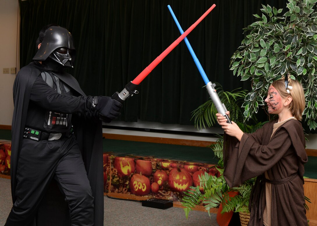 Arron Amargo, age 11, and Morgan Gingerich, age 7, attend the Harvest Festival hosted by the base chapel inside the Chapel Activities Center at Ellsworth Air Force Base, S.D., Oct. 29, 2014. Children arrived dressed in costumes of their favorite characters from movies, video games and comics in celebration of the fall season and Halloween. (U.S. Air Force photo by Senior Airman Anania Tekurio/Released)