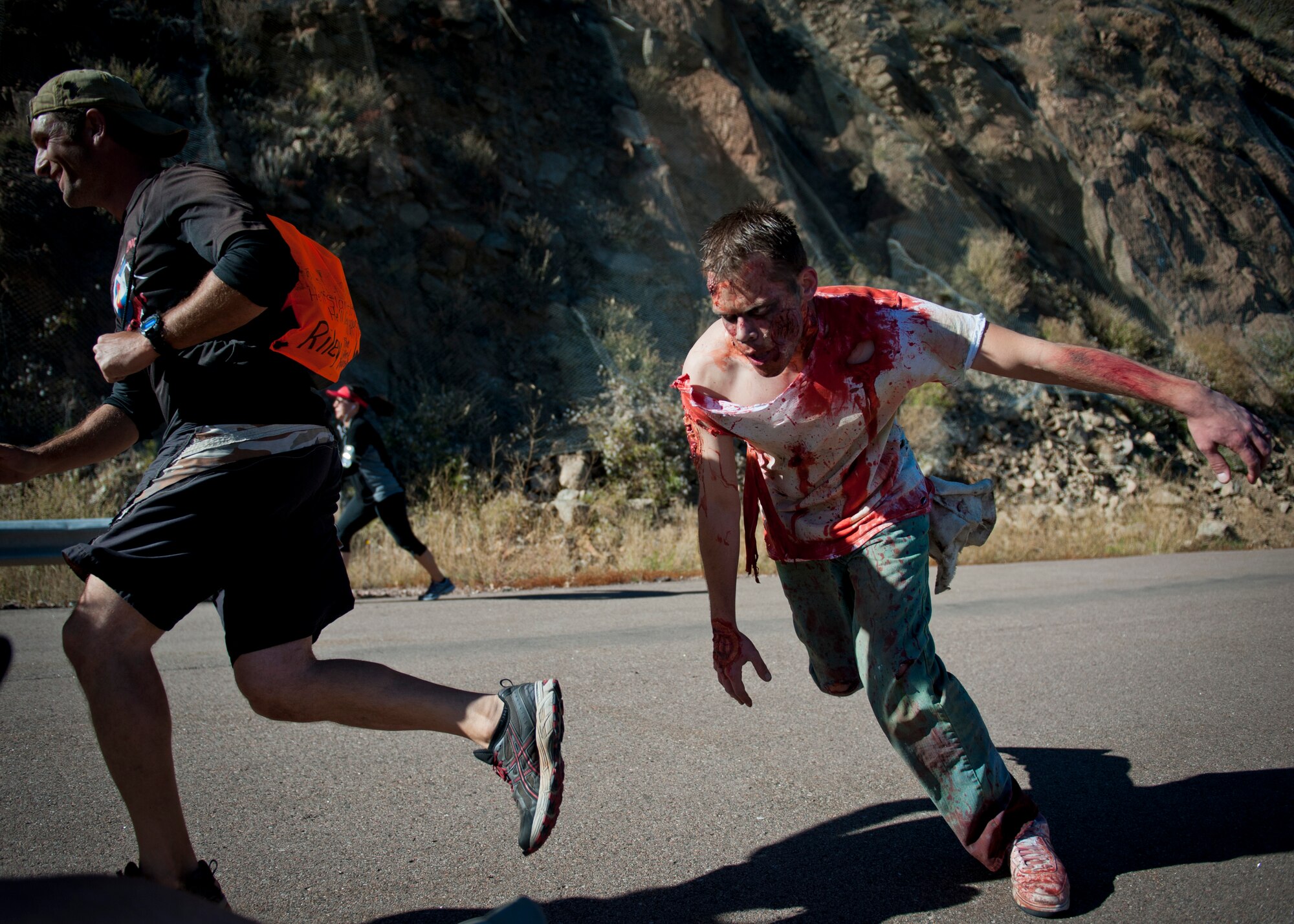 CHEYENNE MOUNTAIN AIR FORCE STATION, Colo. – A runner narrowly avoids a zombie trying to eat him during the first ever 5k Zombie Tunnel Fun Run at Cheyenne Mountain Oct. 30. The Zombie Run was open to any military member and their family from Peterson Air Force Base, Schriever AFB, the U.S. Air Force Academy and Fort Carson. (U.S. Air Force photo/Airman 1st Class Rose Gudex)