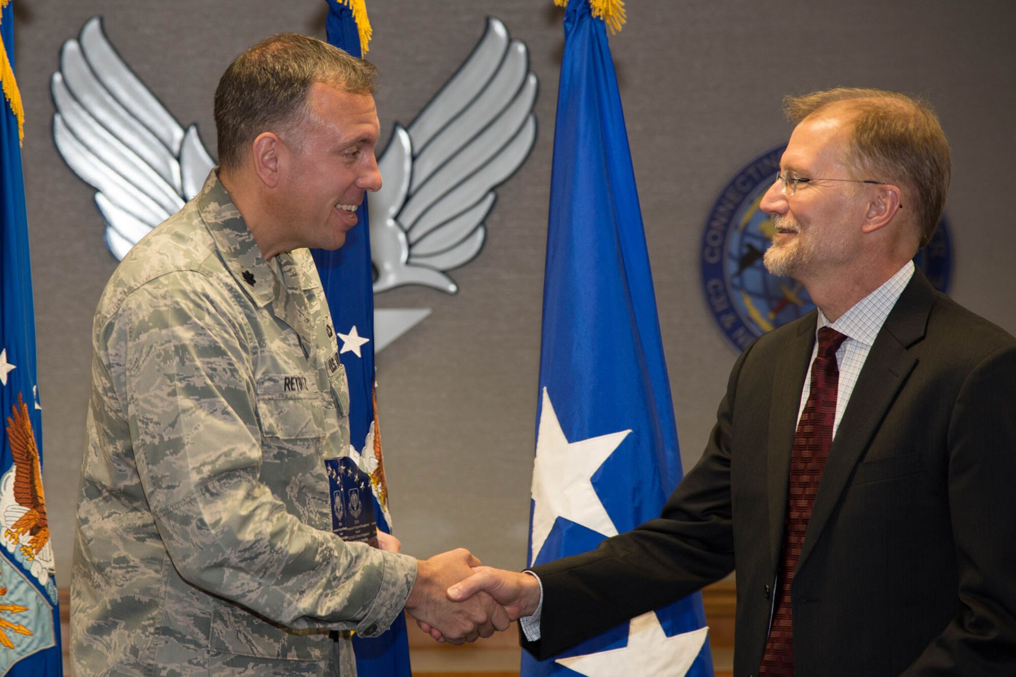 Steven Wert, Battle Management program executive officer, congratulates Lt. Col. Kyle Reybitz, Air and Space Operations Center Weapon System branch chief, during the Air Force Life Cycle Management Center Acquisition Management Awards Oct. 29. Reybitz won the Journeyman Program Management Award in acquisition or services I or non-delegated II category for his work commanding and leading the AOC WS transition. (U.S. Air Force photo by Mark Herlihy) 
