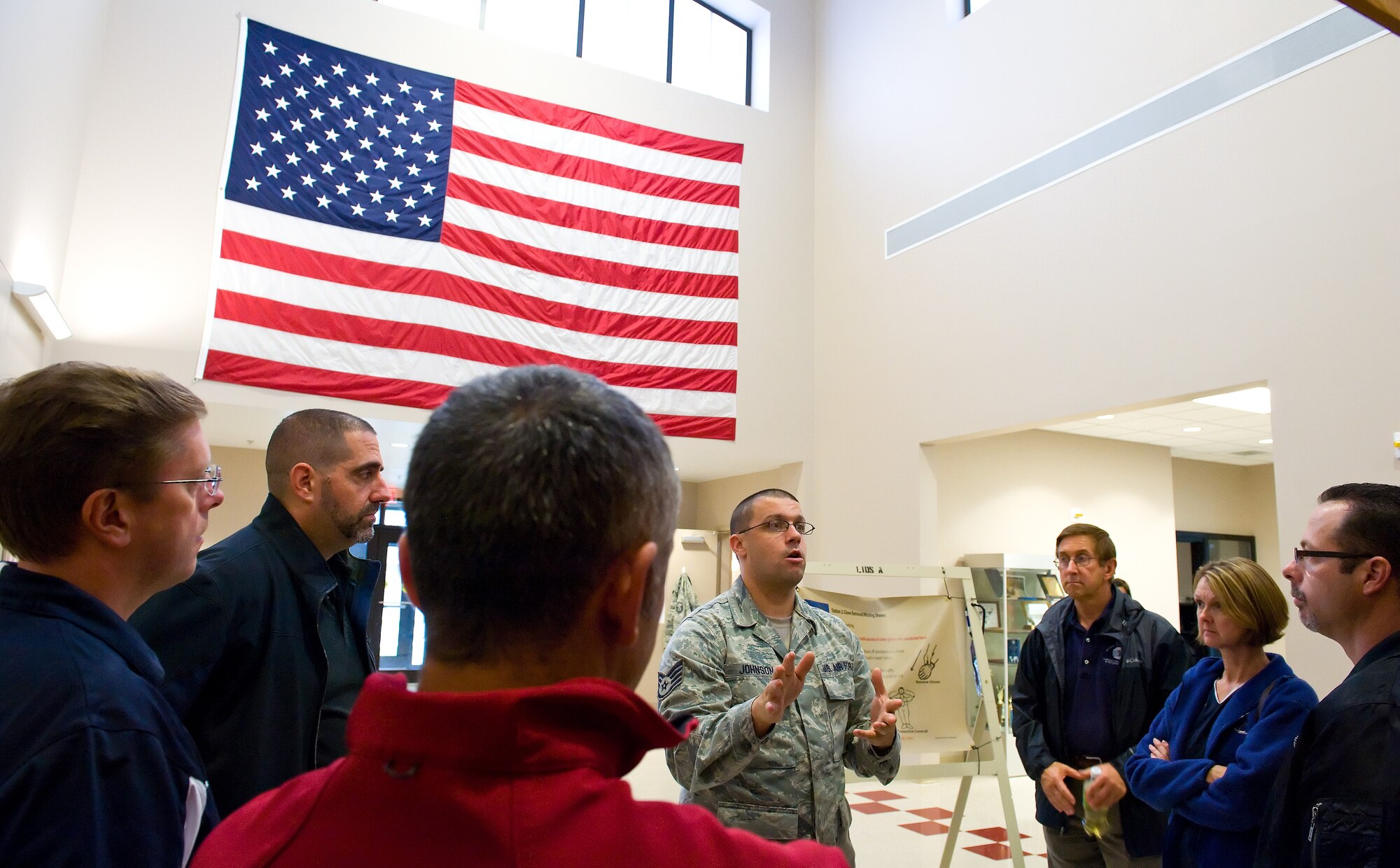 Staff Sgt. Jacob Johnson, 436th Operations Support Squadron aircrew flight equipment training instructor, talks to Team Dover honorary commanders Oct. 29, 2014, at Dover Air Force Base, Del. Johnson briefed the honorary commanders on aircrew decontamination procedures, survival equipment usage and night vision goggle operations. (U.S. Air Force photo/Roland Balik)