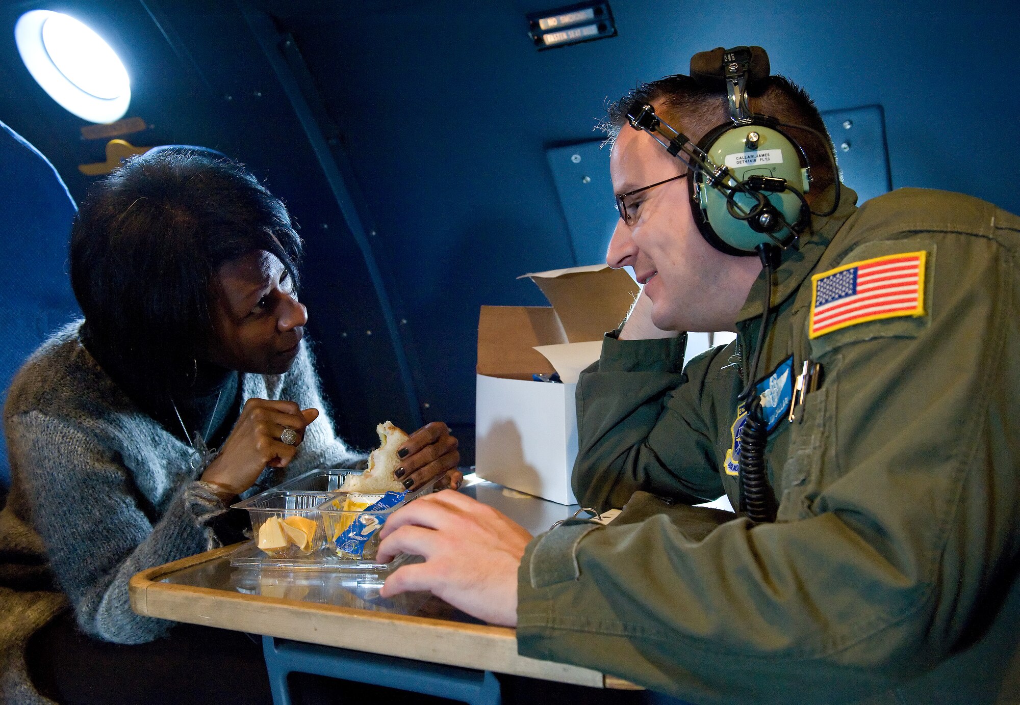 S. Renee Smith, Air Force Mortuary Affairs Operations honorary commander, Dover Air Force Base, Del., left, talks with Master Sgt. James Callari, 9th Airlift Squadron loadmaster, right, in the crew relief compartment of a C-5M Super Galaxy while in-flight during an air refueling flight Oct. 29, 2014. Smith sat behind the pilots during the approach and landing back at Dover AFB. (U.S. Air Force photo/Roland Balik)