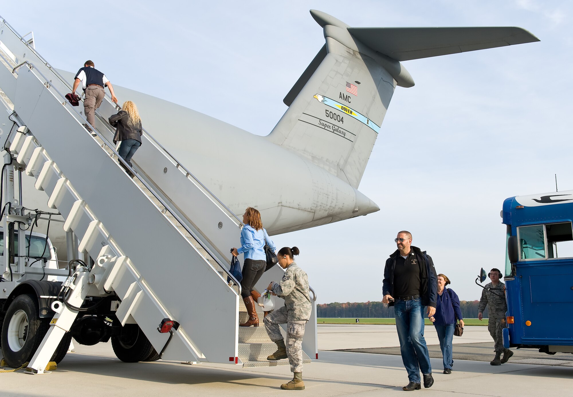 Team Dover honorary commanders and 436th Airlift Wing public affairs ambassadors go up the stairs leading to the troop compartment of a C-5M Super Galaxy Oct. 29, 2014, at Dover Air Force Base, Del. Half of the honorary commanders sat up front in the flight deck during takeoff while the other half sat in the troop compartment. Midway through the flight, they swapped out positions. (U.S. Air Force photo/Roland Balik)