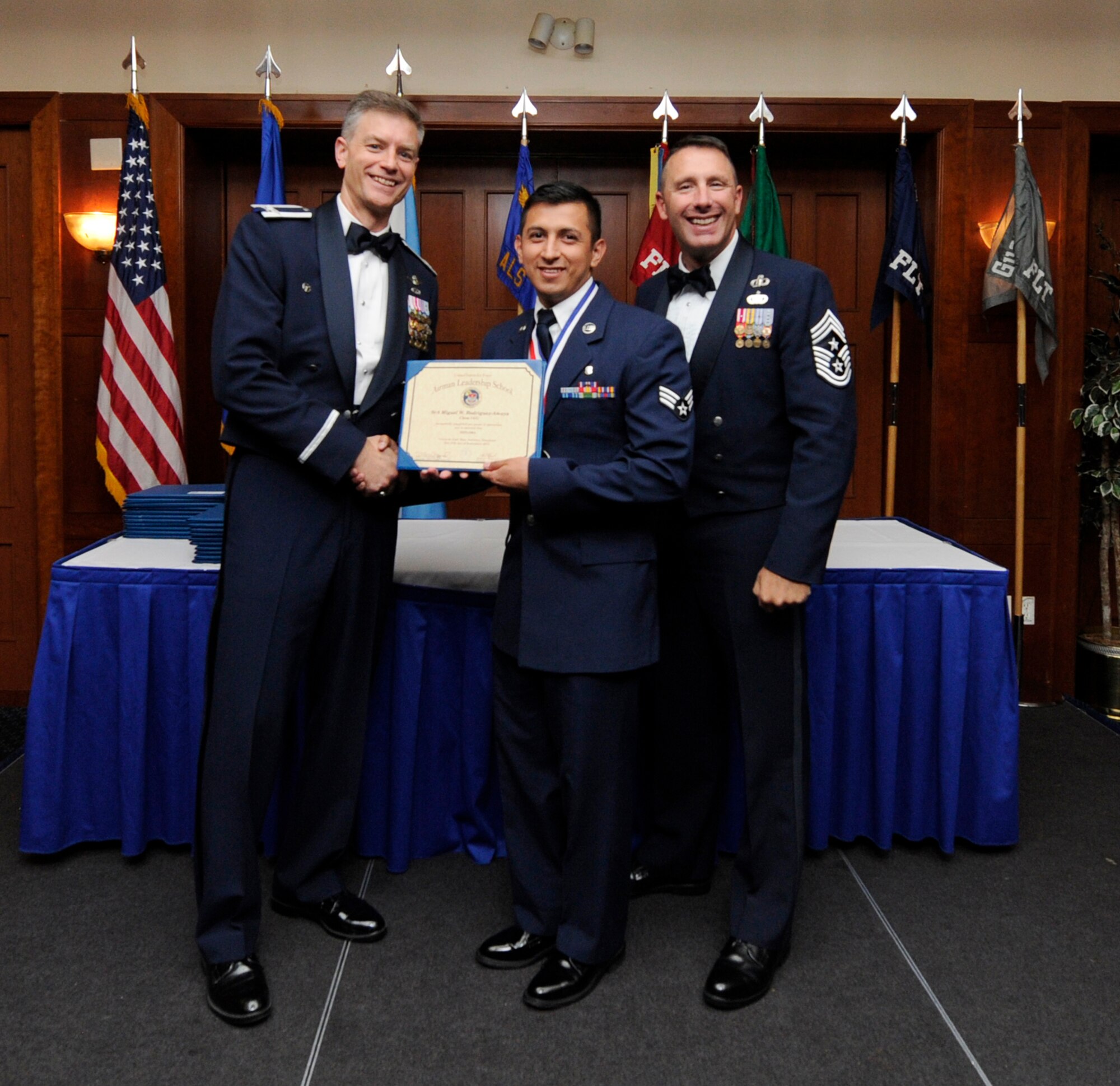 Airman Leadership School (ALS) is a five-week professional military education course which serves as the educational bedrock for new noncommissioned officers. Col. Daniel Waters, 11th Wing Vice Commander and Chief Master Sgt. Vance Kondon, 11th Wing Command Chief present Sr. Airman  Miguel Rodriguez-Amaya, from 779th Medical Group Medical Support Squadron, with his ALS Graduation Certificate. (AF File Photo)