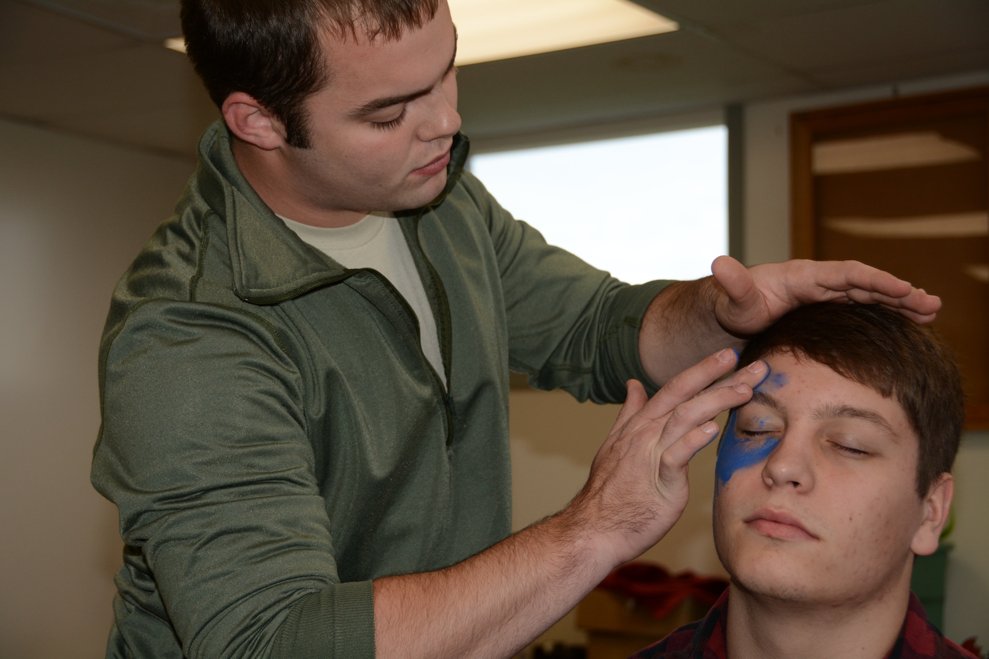 Senior Airman Greg Meyer, 512th Aerospace Medicine Squadron, applies makeup onto the face of Delaware Civil Air Patrol cadet John Boyer Nov. 2, 2014, at Dover Air Force Base, Del. Boyer and other CAP cadets played the roles of victims during a training exercise to prepare 512th AMDS reservists to respond to real world mass casualty emergencies. (U.S. Air Force photo/Senior Airman Joe Yanik)