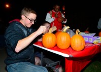 Airman 1st Class Kyle Ferry, 436th Operations Support Squadron air traffic controller apprentice, carves a pumpkin during a combined dinner and “Trunk-or-Treat” event sponsored by the Chief’s Group and Airmen Dorm Council Oct. 30, 2014, at Dover Air Force Base, Del. Free pumpkins were provided for Airmen and Team Dover families to carve during the Halloween event and a gift card was given for the best carved pumpkin. (U.S. Air Force photo/Airman 1st Class William Johnson)