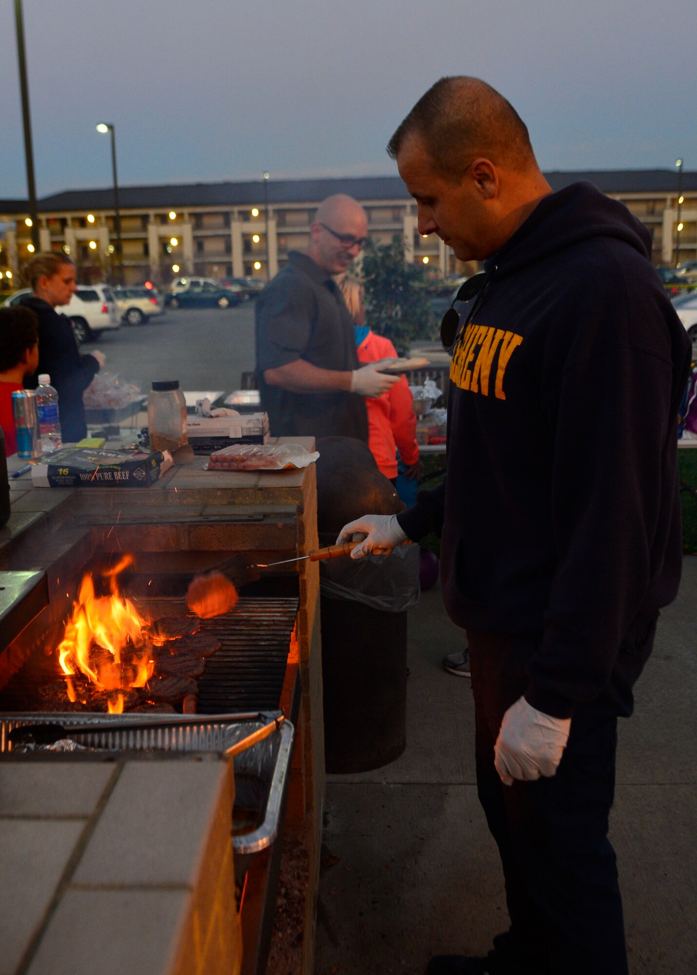 Chief Master Sgt. Bodie McCoy, 436th Medical Group superintendent, flips a hamburger during a combined dinner and “Trunk-or-Treat” event sponsored by the Chief’s Group and Airmen Dorm Council Oct. 30, 2014, at Dover Air Force Base, Del. The Halloween event was hosted for Airmen who live in the dorms and families of Team Dover. (U.S. Air Force photo/Airman 1st Class William Johnson)