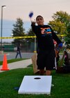 Airman 1st Class Armando Almendariz, 9th Airlift Squadron aviation resource manager, tosses a bean bag during a game of corn hole at a combined dinner and “Trunk-or-Treat” event sponsored by the Chief’s Group and Airmen Dorm Council Oct. 30, 2014, at Dover Air Force Base, Del. A free raffle was also held for gift cards and a 32-inch TV.  (U.S. Air Force photo/Airman 1st Class William Johnson)