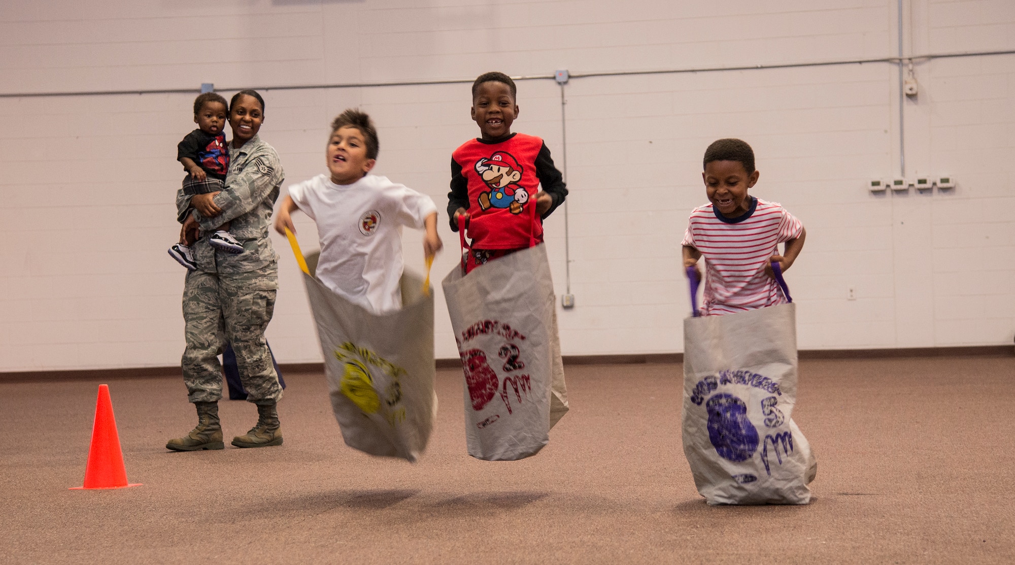 Children compete in a sack race during the Fall Festival for Deployed Families Oct. 30, 2014, at Moody Air Force Base, Ga. The Airman and Family Readiness Center hosts quarterly events for the families of deployed Airmen. (U.S. Air Force photo by Senior Airman Sandra Marrero/Released)
