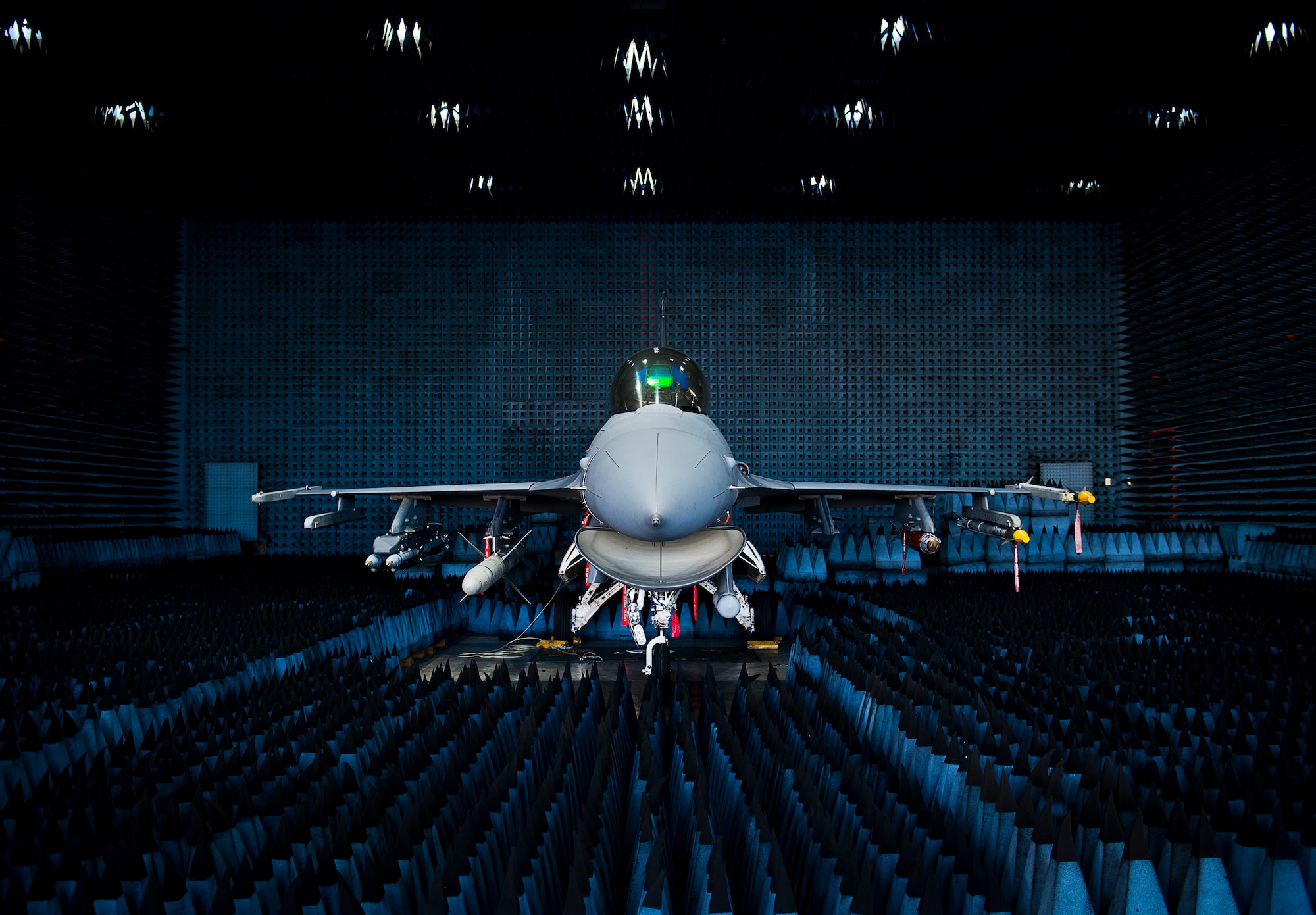 A 40th Flight Test Squadron F-16 Fighting Falcon sits in the anechoic chamber after completion of the initial round of testing simulations on the new M-7 software upgrade Oct. 30 at Eglin Air Force Base, Fla.  The M-7 software package will provide multiple advanced capabilities to the aircraft.  The anechoic chamber, located in the Joint Preflight Integration of Munitions and Electronic Systems building, is a room designed to stop reflections of either sound or electromagnetic waves. The room is insulated from exterior sources of noise.  JPRIMES provides an environment to facilitate testing air-to-air and air-to-surface munitions and electronics systems on full-scale aircraft and land vehicles prior to open air testing. (U.S. Air Force photo/Samuel King Jr.)