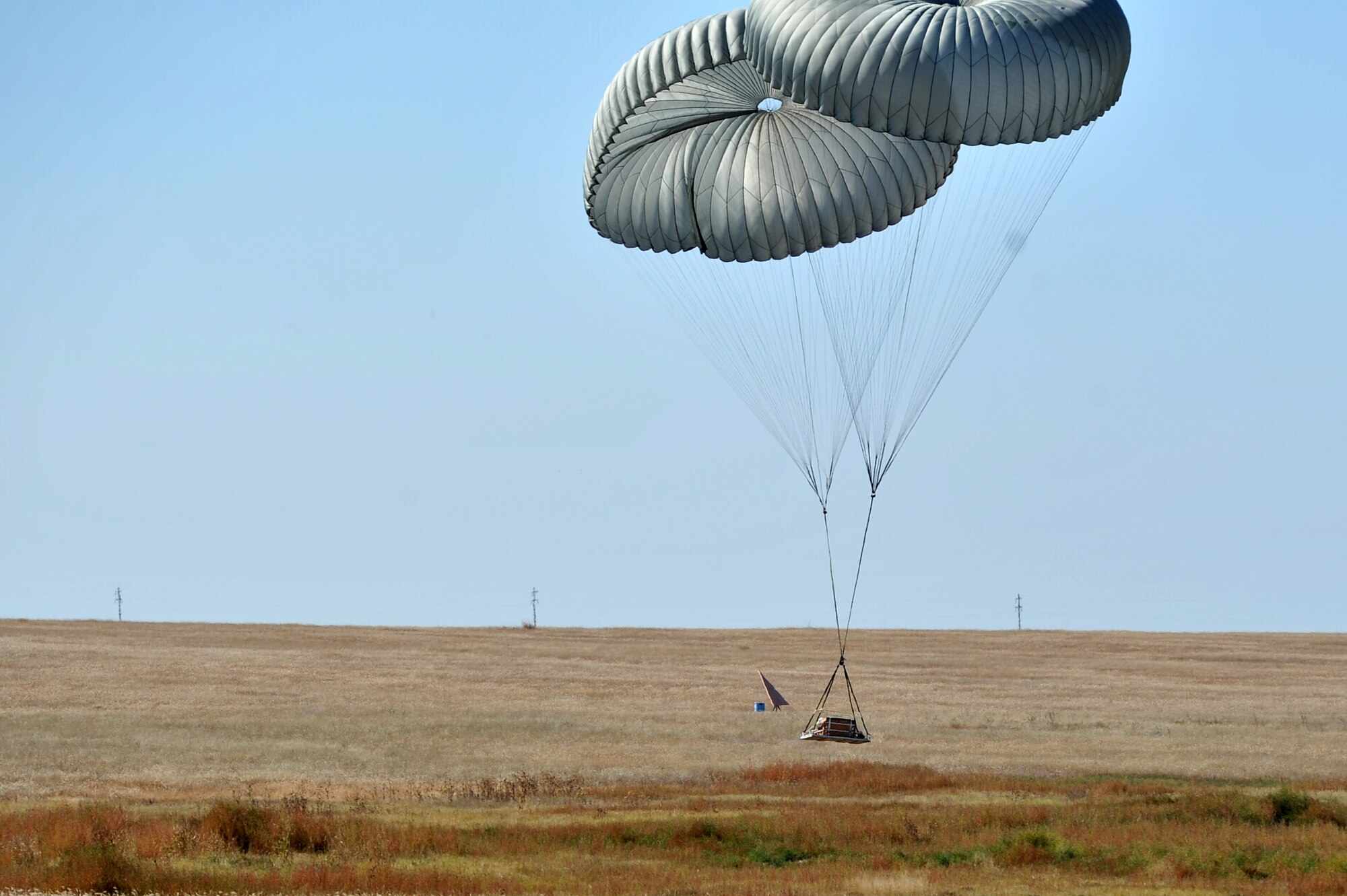 HOLLIS, Okla. – A cargo pallet safely lands in a field after being dropped from a U.S. Air Force C-17 Globemaster III cargo aircraft during an airdrop training mission Oct. 30, 2014. The pallets used for training are made of lumber or water and can weigh up to 4,000 pounds. The 97th Logistics Readiness Squadron provides the pallets to the 58th Airlift Squadron used during routine loadmaster training missions based out of Altus Air Force Base. (U.S. Air Force Photo by Senior Airman Dillon Davis/Released)