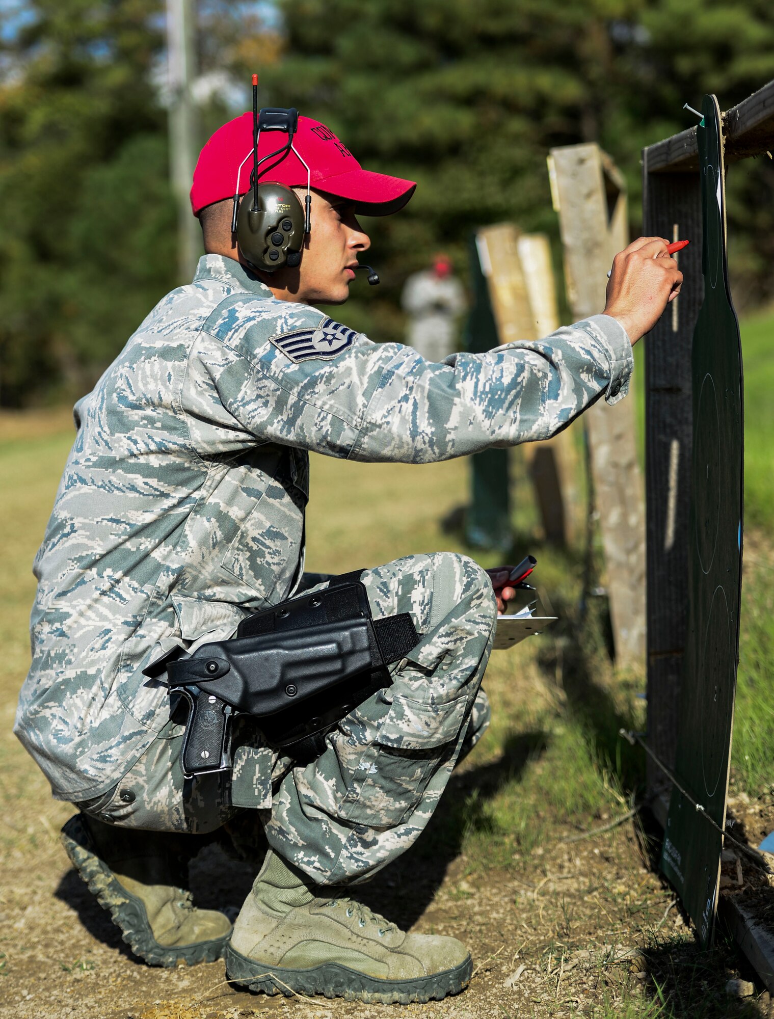 U.S. Air Force Staff Sgt. Abel Feliciano, 633rd Security Forces Squadron Combat Arms Training and Maintenance instructor, inspects a used target during 633rd SFS M-4 carbine training at Fort Eustis, Va., Oct. 30, 2014. Instructors are responsible for training Airmen on the use, maintenance and repairing of firearms.  (U.S. Air Force photo by Senior Airman Kayla Newman/Released) 