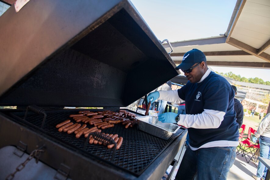 U.S. Air Force Chief Master Sgt. Will Hardin, 23d Civil Engineer Squadron fire prevention chief, grills food during Retiree Appreciation Day Nov. 1, 2014, at Moody Air Force Base, Ga. After a base tour, retirees ate lunch to conclude the day’s events. (U.S. Air Force photo by Airman 1st Class Dillian Bamman/Released)