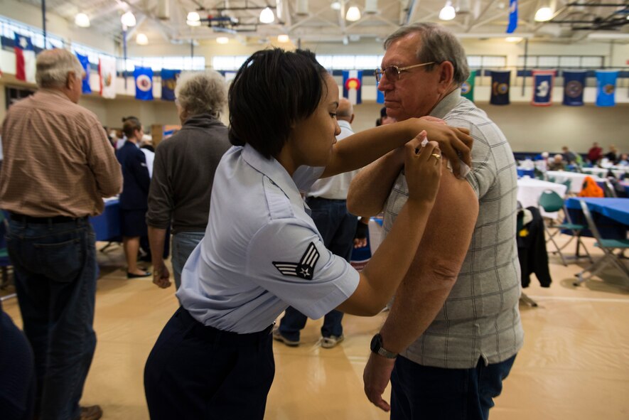 U.S. Air Force Senior Airman Gelisa Adams, 23d Medical Group immunizations technician, administers a flu vaccination during the Retiree Appreciation Day health and information fair Nov. 1, 2014, at Moody Air Force Base, Ga. More than 100 retirees and their family members received flu vaccinations from the 23d MDG. (U.S. Air Force photo by Airman 1st Class Dillian Bamman/Released)