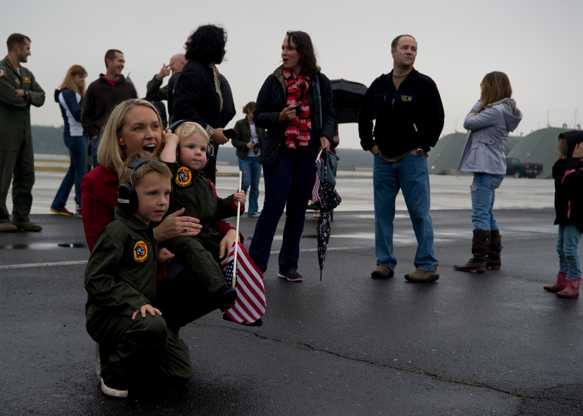 Melissa Biedenbach waits on the flightline at Misawa Air Base, Japan, for the return of U.S. Air Force Lt. Col. Joseph Biedenbach, 13th Fighter Squadron director of operations, Nov. 1, 2014. Biedenbach was one of several pilots who returned after a six-month-long deployment in support of U.S. Air Forces Central Command. During the deployment, members of the 13 FS supported the U.S. Air Forces Central Command mission by aggressively planning, preparing and presenting executable options to the commanders while standing ready to support contingency operations. (U.S. Air Force photo by Airman Jordyn Rucker/Released)