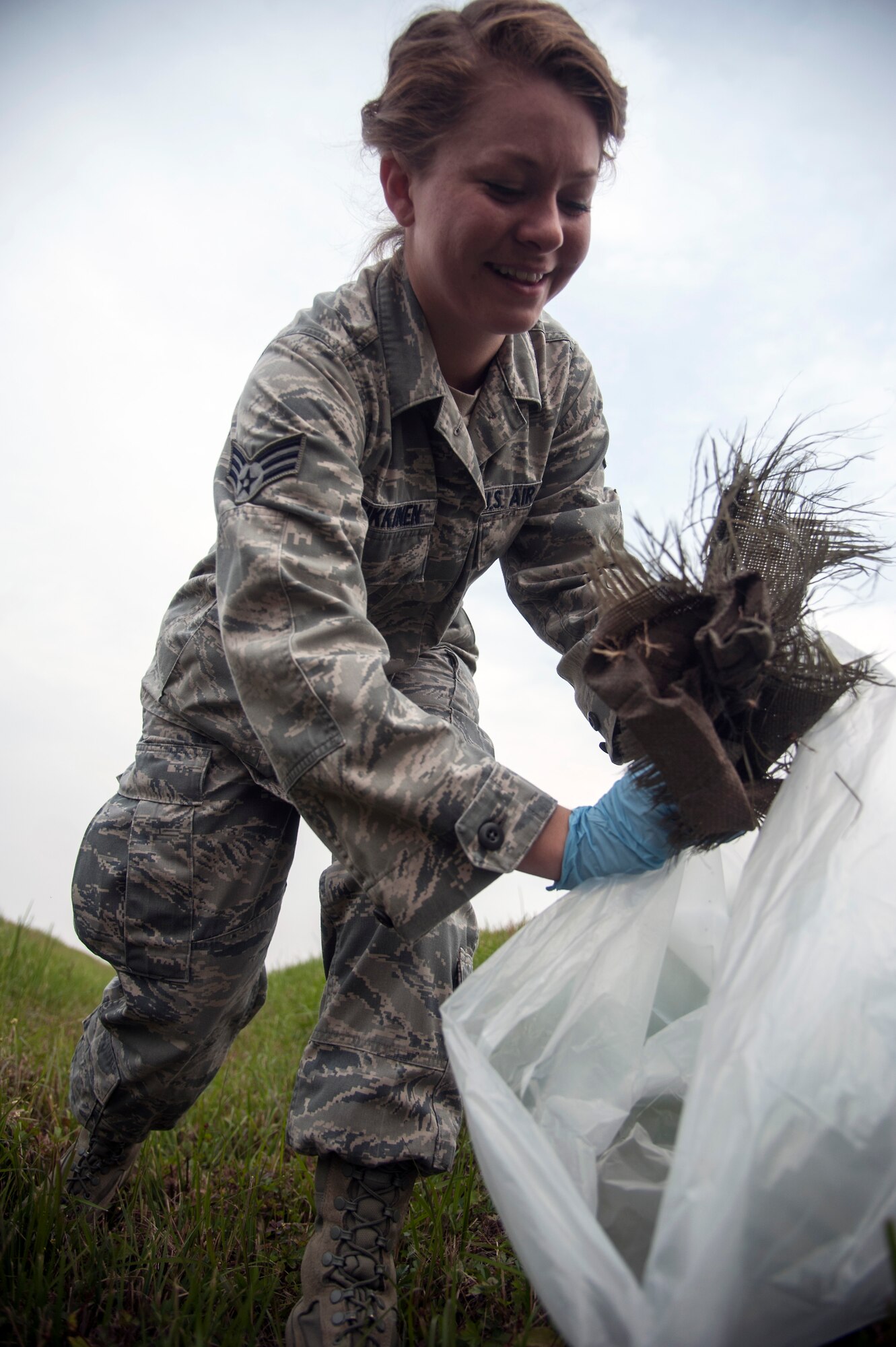 Senior Airman Katrina Heikkinen, 8th Fighter Wing public affairs photojournalist, picks up trash from the flight line during a foreign object debris detection walk at Kunsan Air Base, Republic of Korea, Oct. 30, 2014. The FOD walk was held in conjunction to the runway being repaired and in preparation for the return of the Wolf Pack’s F-16 Fighting Falcons. (U.S. Air Force photo by Senior Airman Taylor Curry/Released)