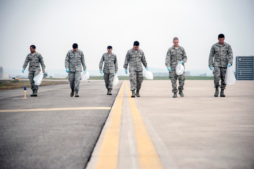 Wolf Pack Airmen perform a foreign object debris detection walk on the flight line at Kunsan Air Base, Republic of Korea, Oct. 30, 2014. The FOD walk was held in conjunction to the runway being repaired and in preparation for the return of the Wolf Pack’s F-16 Fighting Falcons. (U.S. Air Force photo by Senior Airman Taylor Curry/Released)  