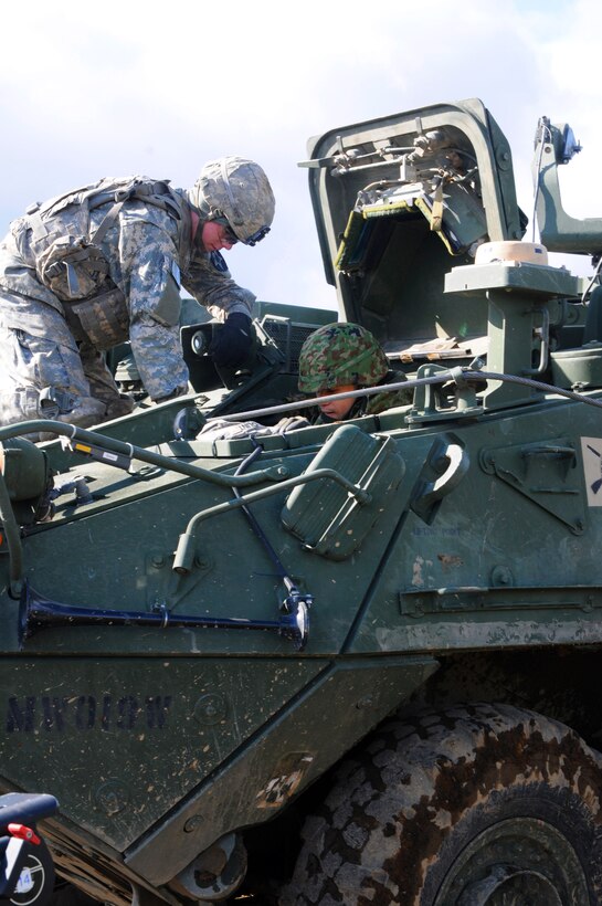 U.S. Army Pfc. Devin Gentry, left, shows the Stryker 120 mm mortar system to a Japanese soldier during the Orient Shield exercise on Camp Chitose, Hokkaido, Japan, Oct. 28, 2014. Gentry is assigned to the 2nd Battalion, 1st Infantry Regiment from Joint Base Lewis-McChord, Wash.