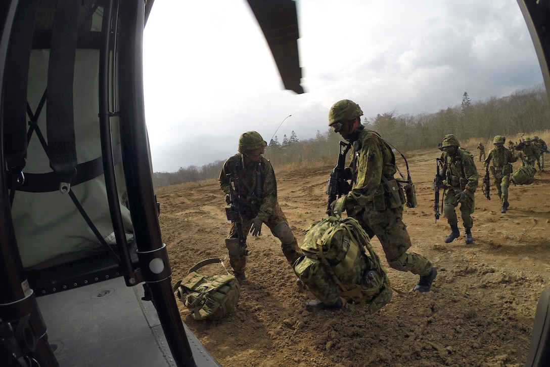 Japanese soldiers load their gear into a U.S. Army UH-60 Black Hawk helicopter during air assault training in support of the Orient Shield exercise on Camp Chitose, Hokkaido, Japan, Oct. 31, 2014.