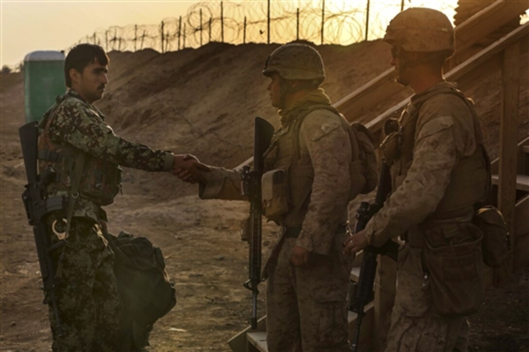 U.S. Marines greet an Afghan soldier as he takes his post on Camp Leatherneck, Helmand province, Afghanistan, Oct. 27, 2014.