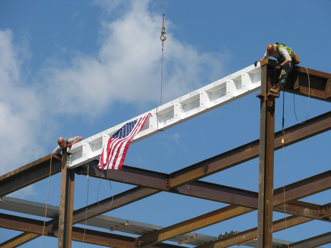 Construction workers proudly hang the American flag on the final piece of structural steel on the new DLA headquarters building at Defense Distribution Depot Susquehanna on Apr. 9.