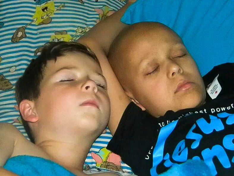 Baily Cooper, left, and Dillon Cooper, sons of Senior Master Sgt. Jason Cooper, 5th Reconnaissance Squadron aircraft maintenance squadron superintendent, lay in bed sleeping together at their home in Las Vegas, Nev. Dillon was diagnosed with having a high-grade Medulloblastoma. Symptoms include repeated episodes of vomiting and a morning headaches, stumbling gait (walk), frequent falls, facial sensory loss or motor weakness. (Courtesy photo)
