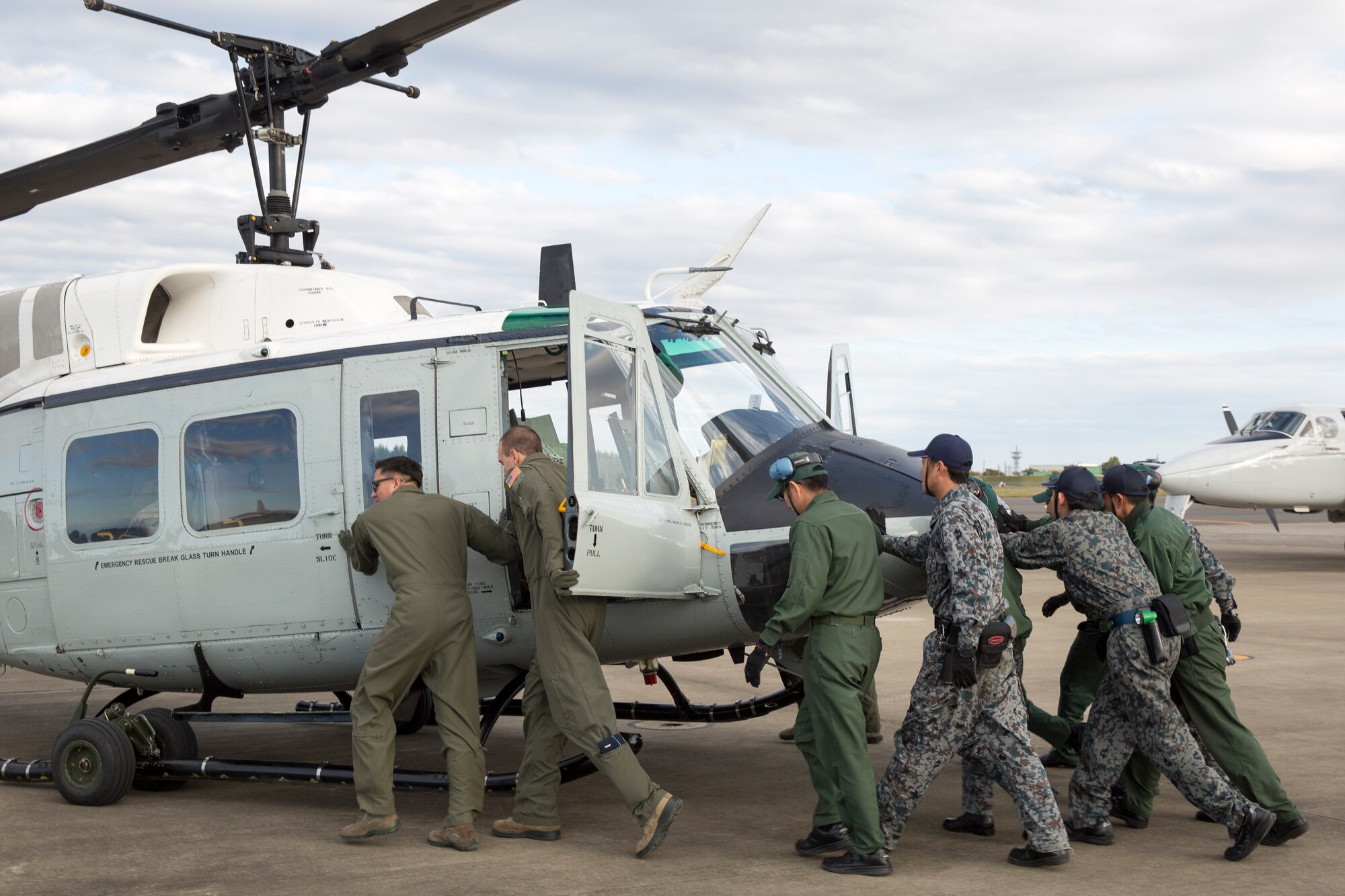 Airmen from the U.S. Air Force and Japan Air Self-Defense Force push back a Yokota UH-1N Iroquis during an annual air show at Iruma Air Base, Japan, Nov. 3, 2014. More than 290,000 people of all ages attended the event. (U.S. Air Force photo by Osakabe Yasuo/Released)